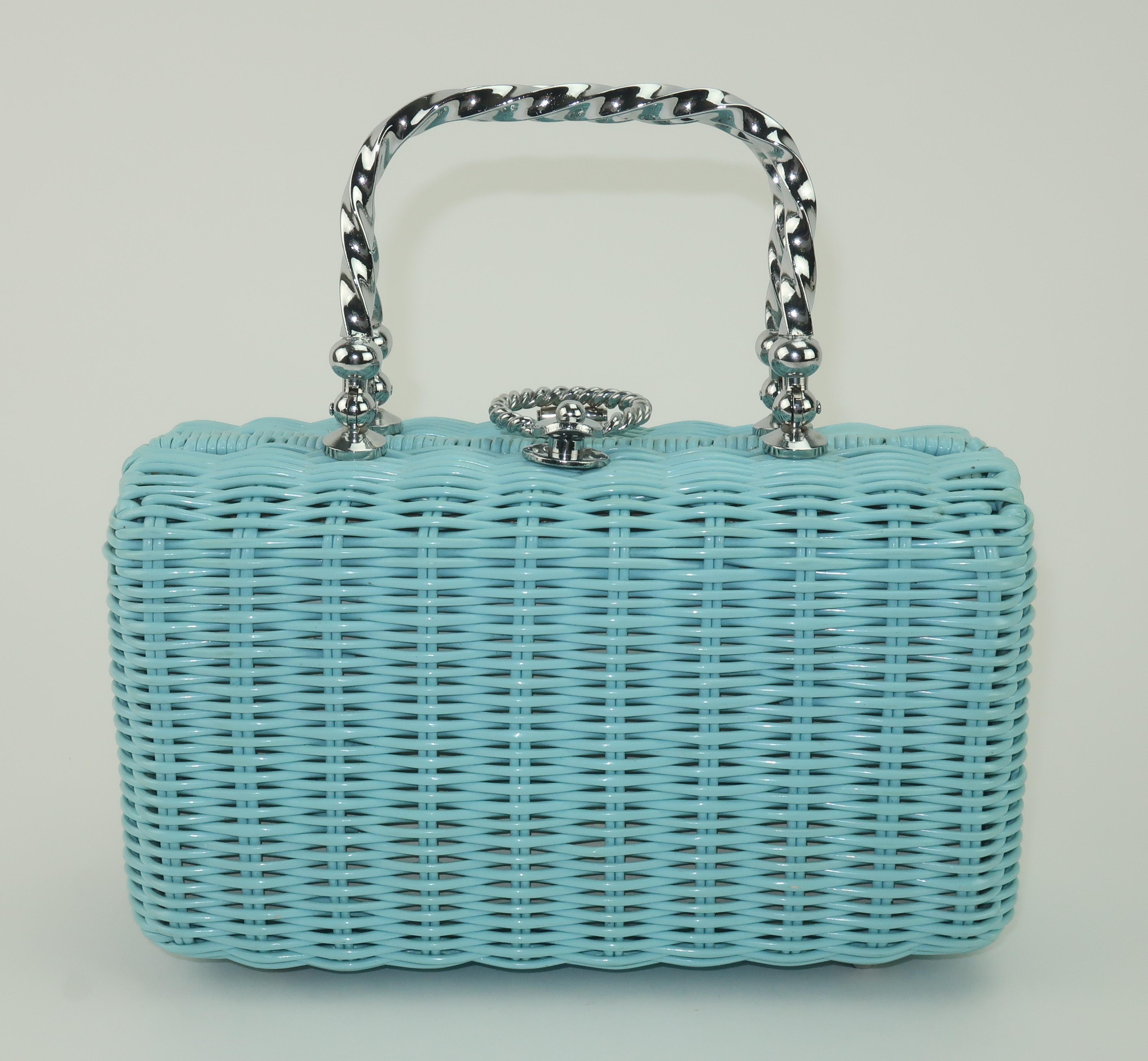 1960's baby blue coated wicker handbag with silver tone metal ring closure and twisted top handles.  The closure is reminiscent of a door knocker and opens to reveal a vinyl lined interior with three compartments including a center zippered pocket. 