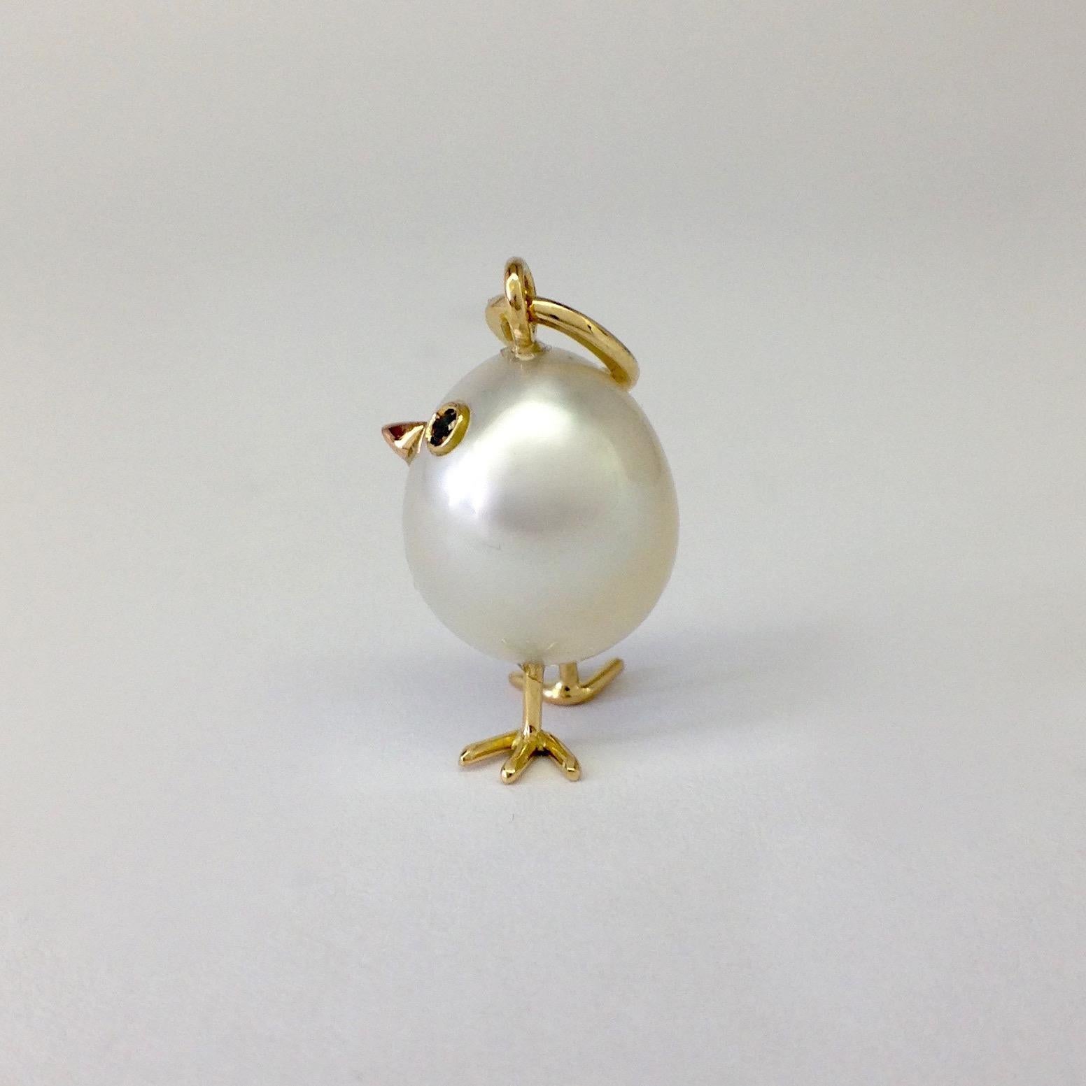 An Australian pearl has been carefully crafted to make a chick. He has his two legs, two eyes encrusted with two black diamonds and his beak. 
The gold is red for the beak, for the other elements it's yellow.
The caliber is ct 0.02
The chain is not