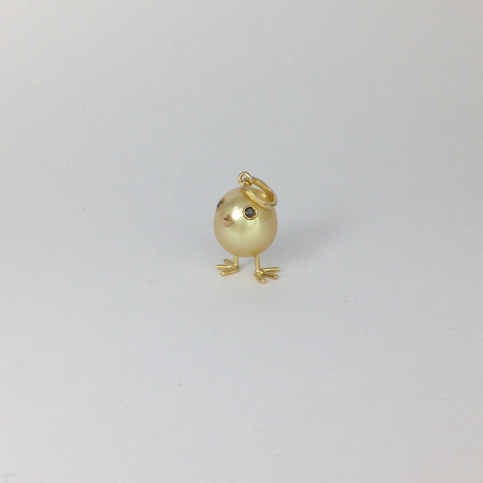 A spherical rare Australian pearl has been carefully crafted to make a chick. He has two legs, two eyes encrusted with two black diamonds. His beak in red gold. 
The gold is yellow.
The caliber is ct 0.03.
The height of the pendant including the