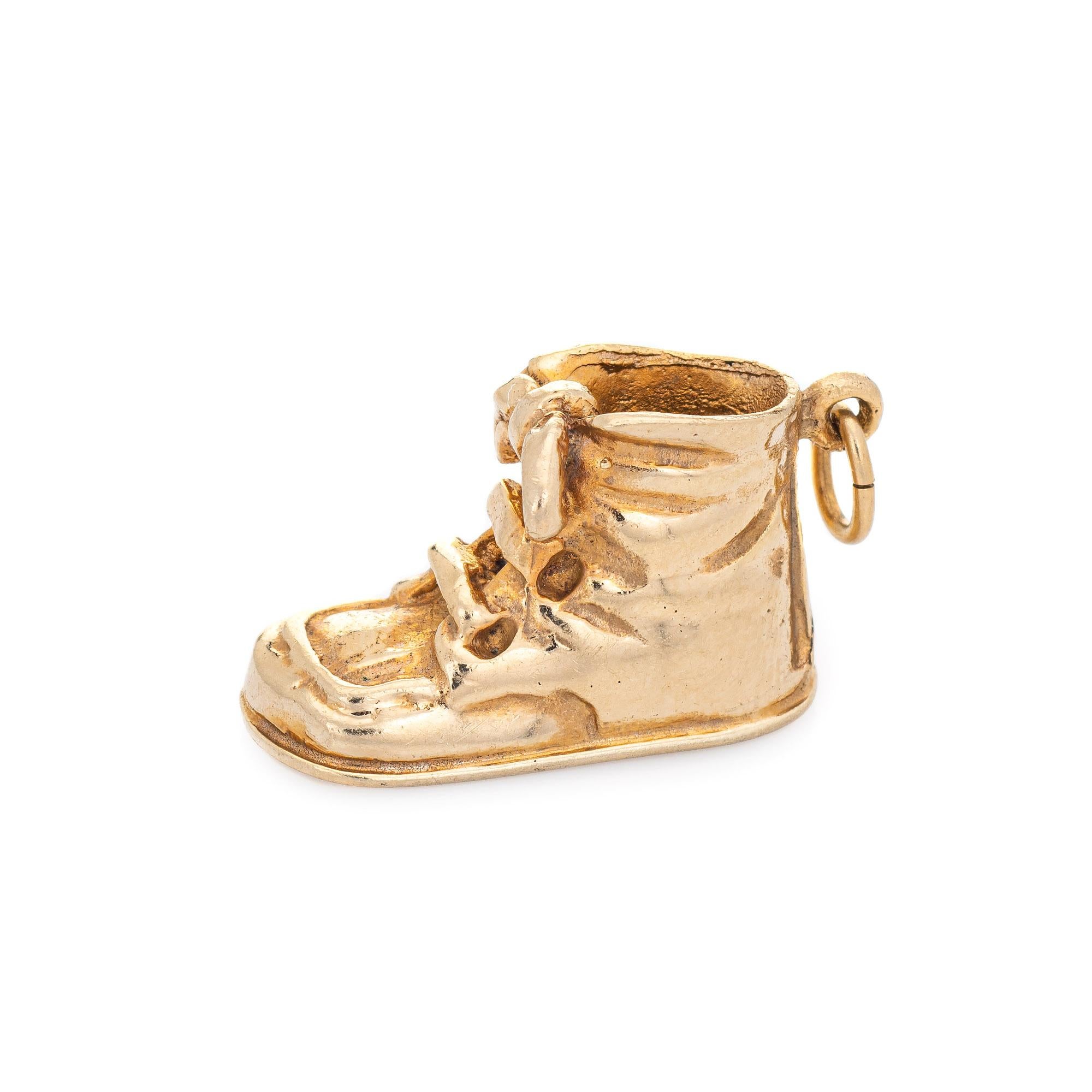 Finely detailed vintage baby shoe charm crafted in 18k yellow gold.  

The baby bootie charm features lifelike detail with creases to the upper boot and a bow tied lace. Ideal worn as a pendant or on a charm bracelet.

The charm is in very good