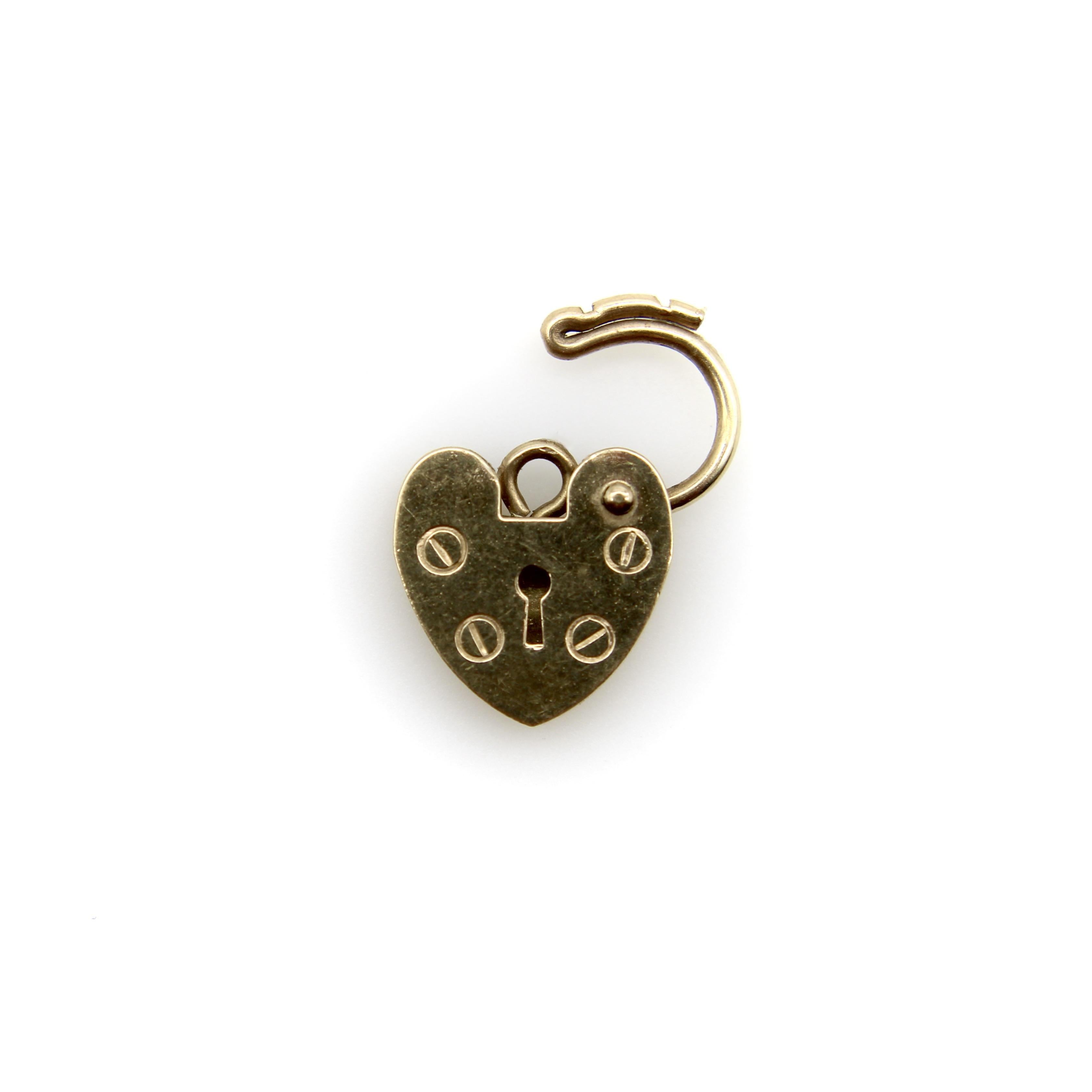 England has a tradition of heart padlock jewelry that dates back to the Victorian era and continues to be seen in jewelry today. This vintage 9k gold charm is the perfect example of the traditional heart padlock—which is typically depicted with four