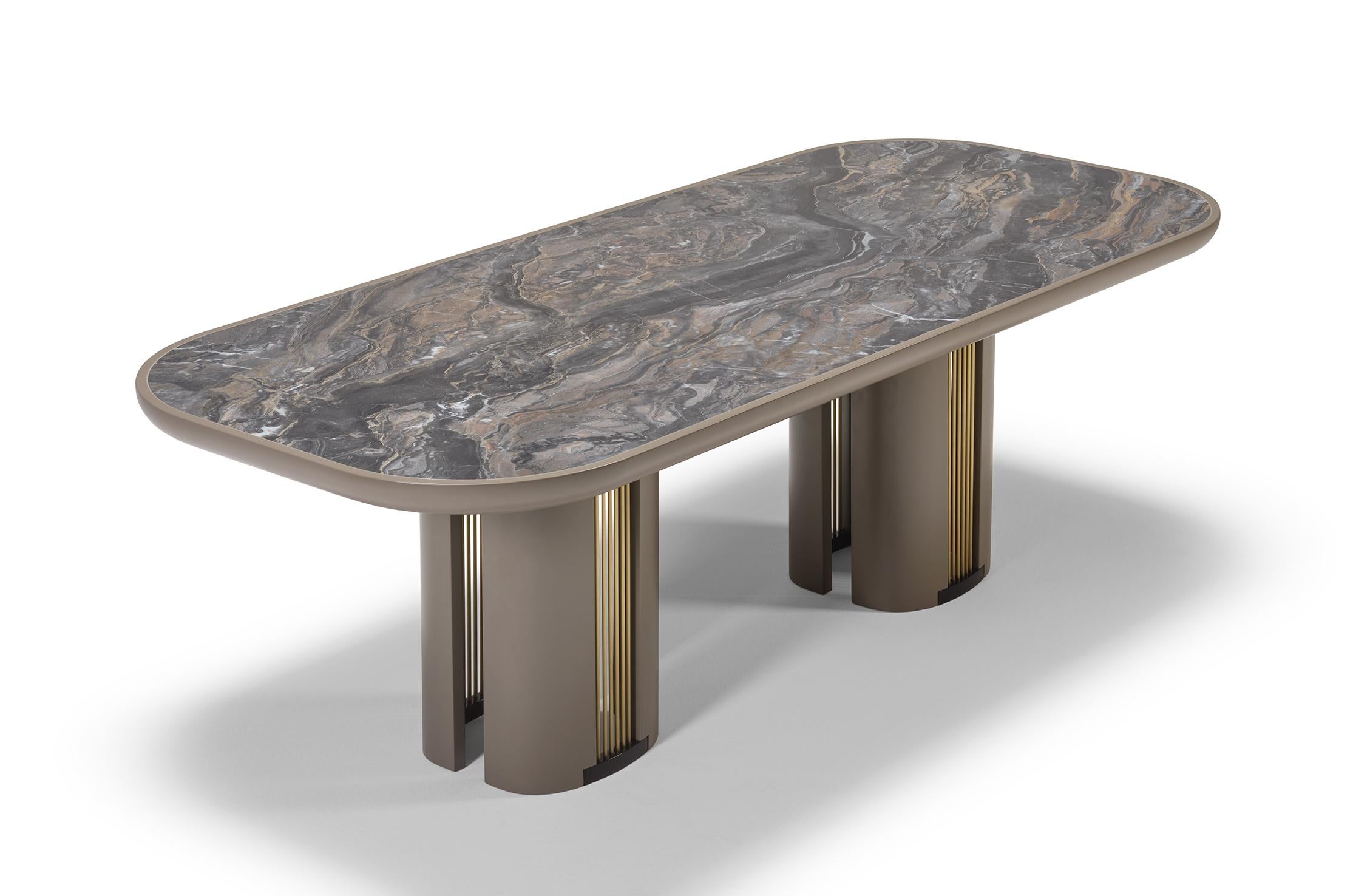 The distinctive BACALL is a very sensual dining table with a strong character. The full-bodied top, finished in ceramic, is settled on the well-gauged legs, which are embellished with the beauty of the brass details. Made of a wooden structure,
