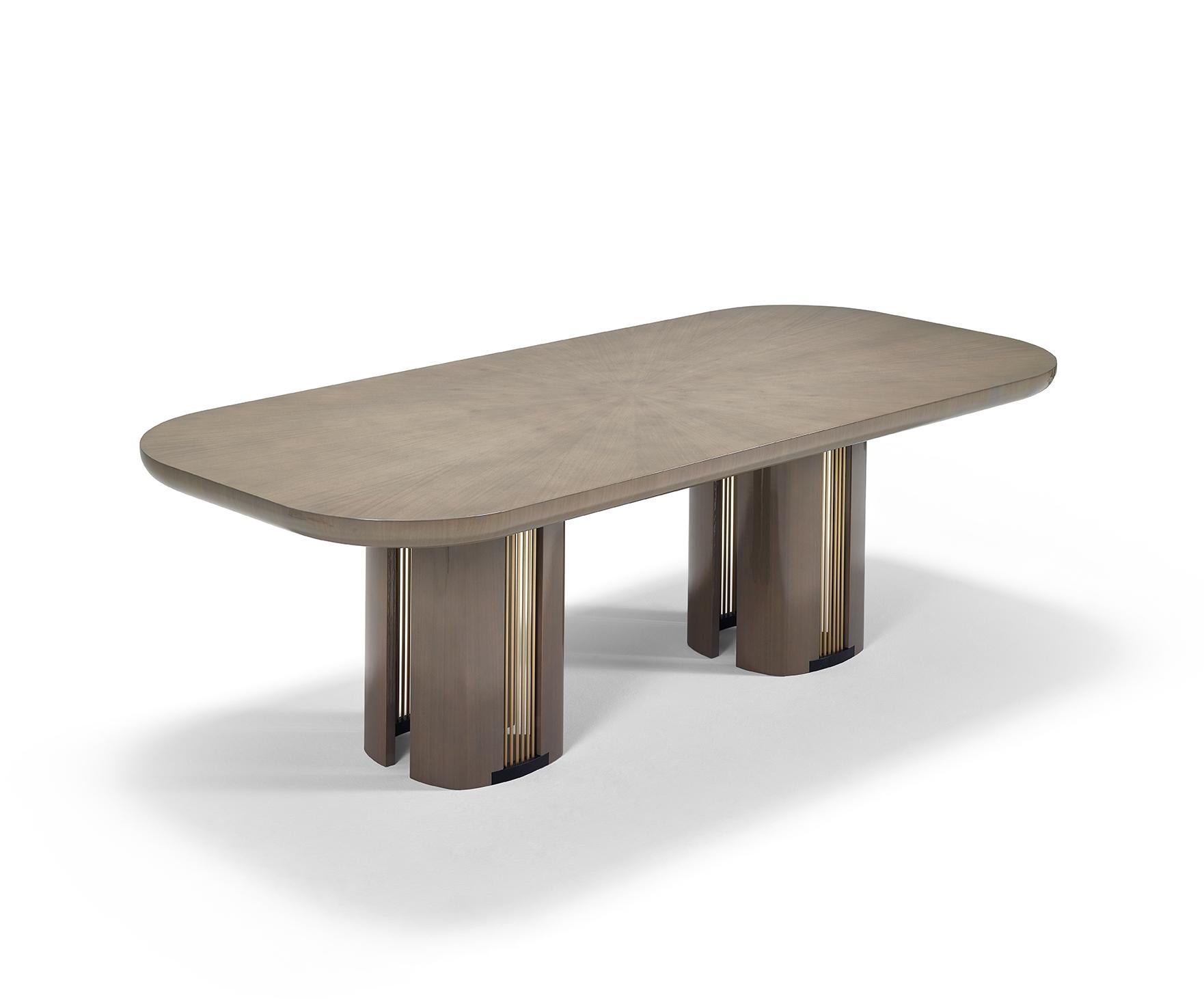 The distinctive BACALL is a very sensual dining table with a strong character. The full-bodied top in wood is settled on the well-gauged legs, which are embellished with the beauty of the brass details. Made of a wooden structure, Bacall can be