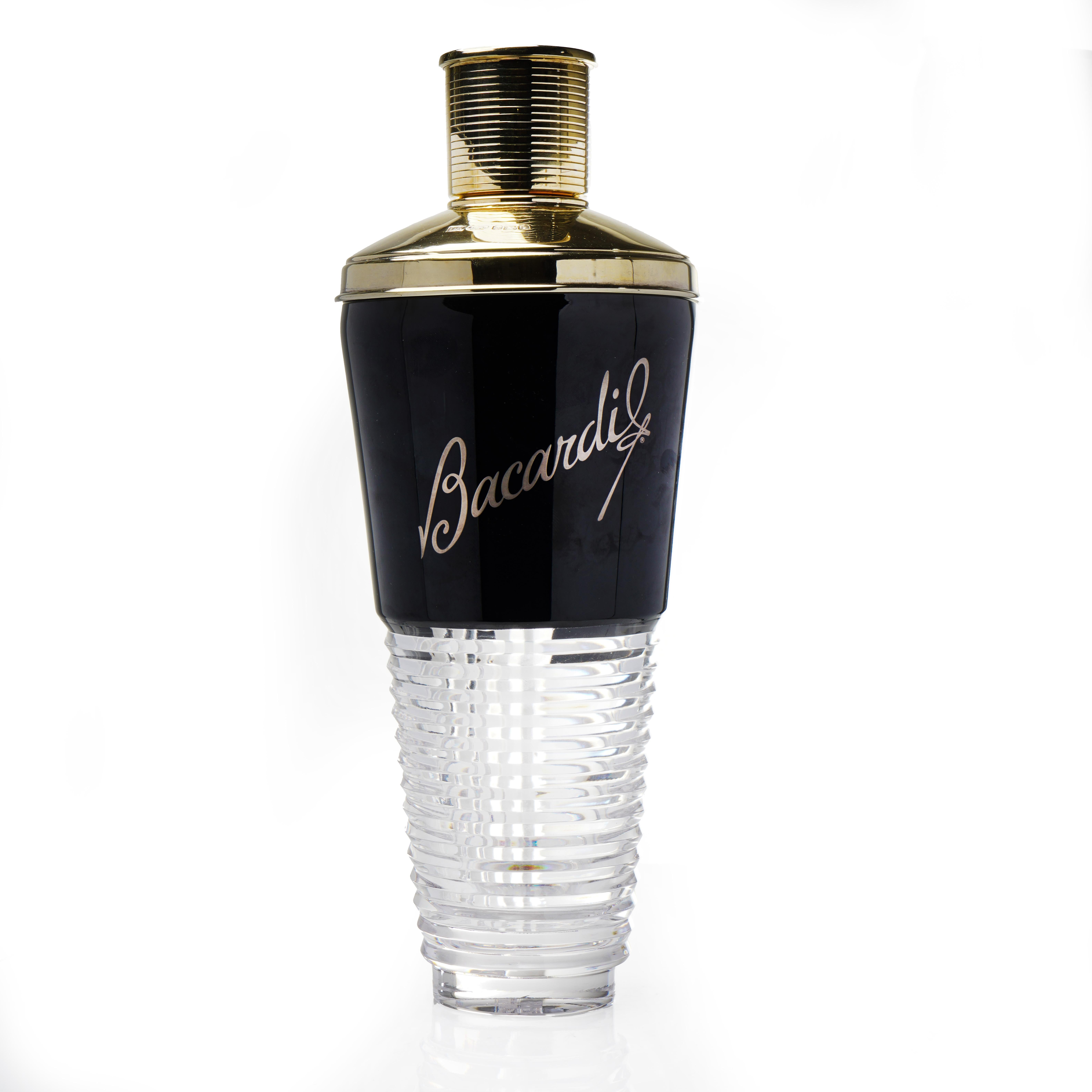 Esta coctelera de competición Bacardi, fabricada en 2007, es una pieza llamativa que combina funcionalidad y estilo. La coctelera tiene un elegante cuerpo de cristal estriado, que contrasta con la tapa de plata pulida,  producido por David Redman