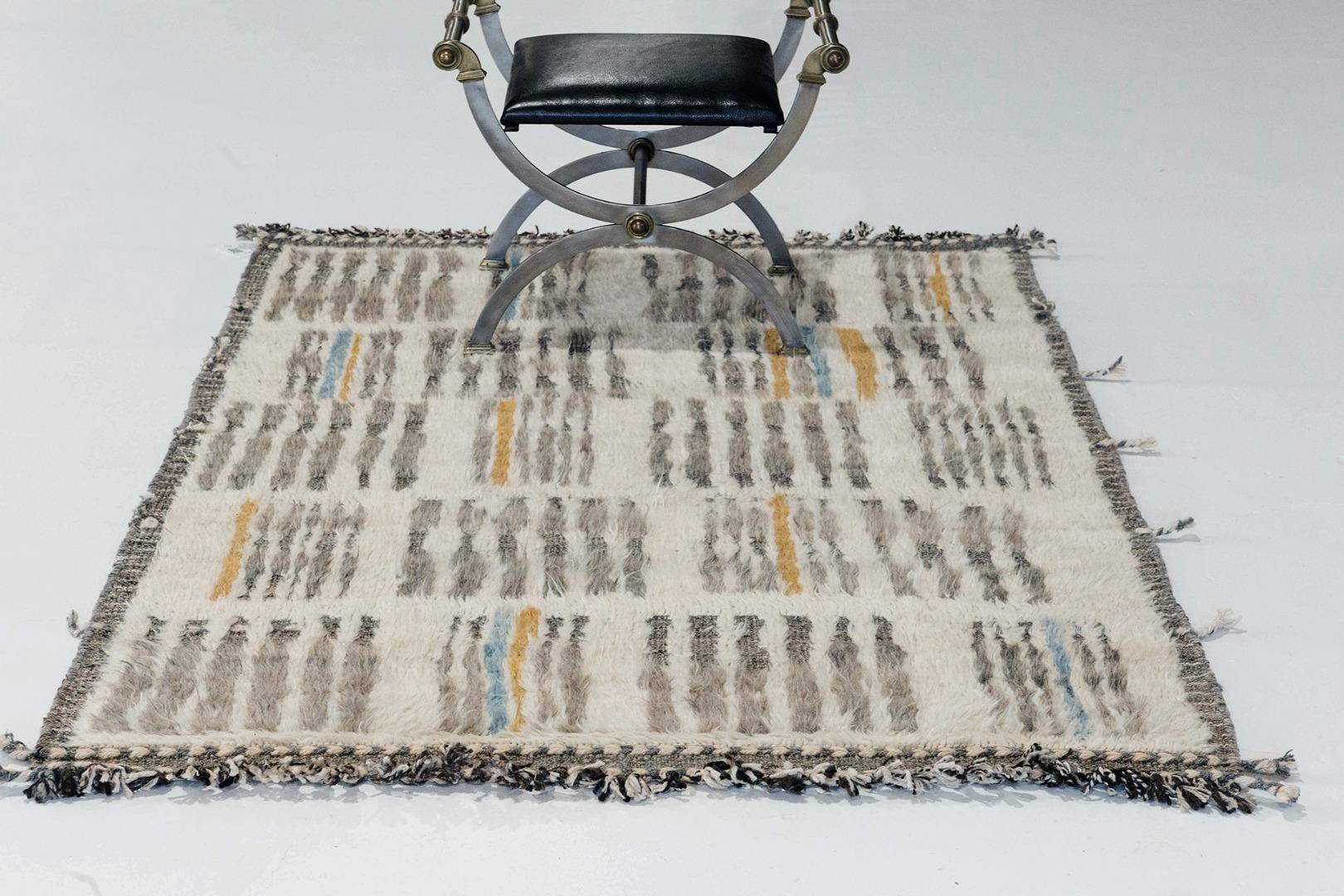Handwoven of wool, 'Baccata' uses linework and color to create definition and movement. Line detailing in taupe, blue, and orange move across the rug with a ivory shag surface. Detailed natural flat weave runs around the border with tassels adding a