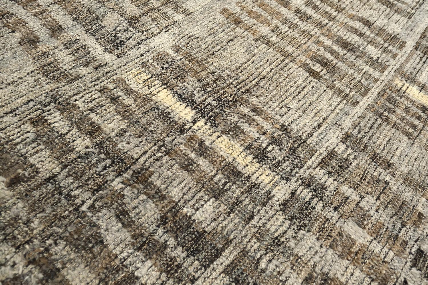 Bacatta uses linework and color to create definition and movement into handwoven wool. Line detailing in neutral tones fascinatingly moves across the rug. Detailed natural pile weave runs around the border with tassels adding an exquisite decorative