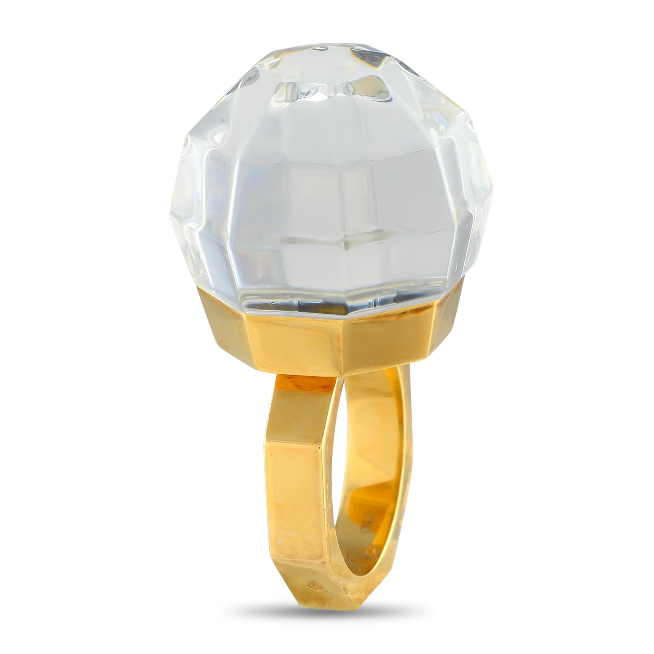 This bold Baccarat ring will continually impress. This piece features an 18K Yellow Gold band that measures 6mm wide  but its the breathtaking multifaceted Crystal center stone that makes it simply unforgettable. A 32mm top height means it will