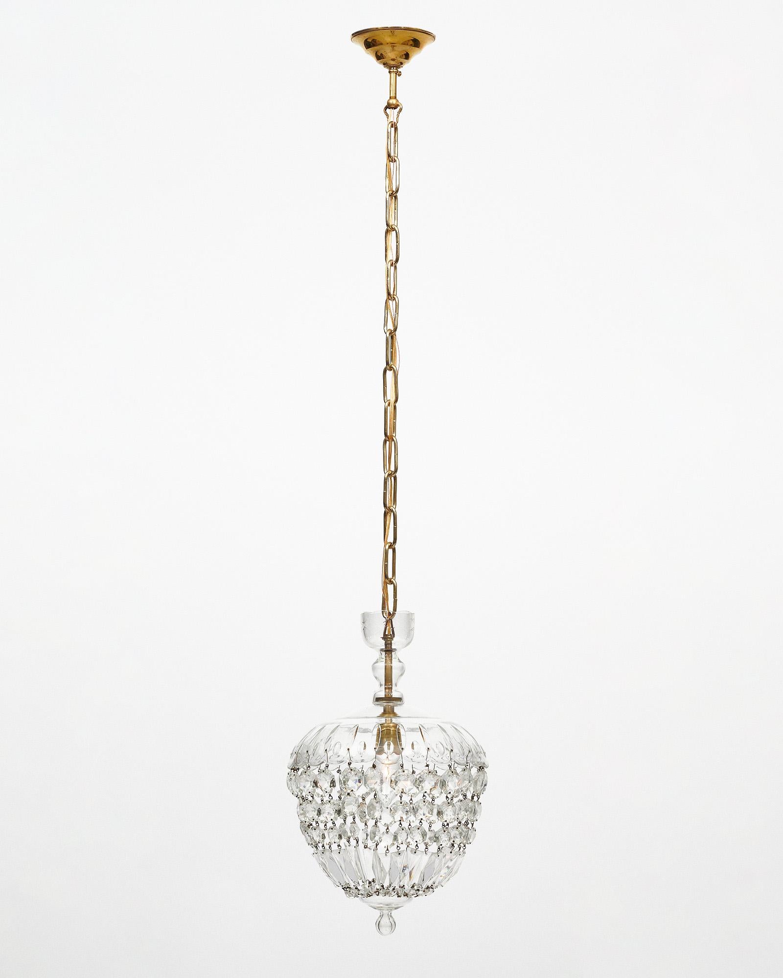 Chandelier/pendant from France in the iconic Baccarat bell shape. The crystal top holds strands of cut crystal elements that come together at the crystal finial. This piece is transparent in color. It has been newly wired to fit US standards.
The