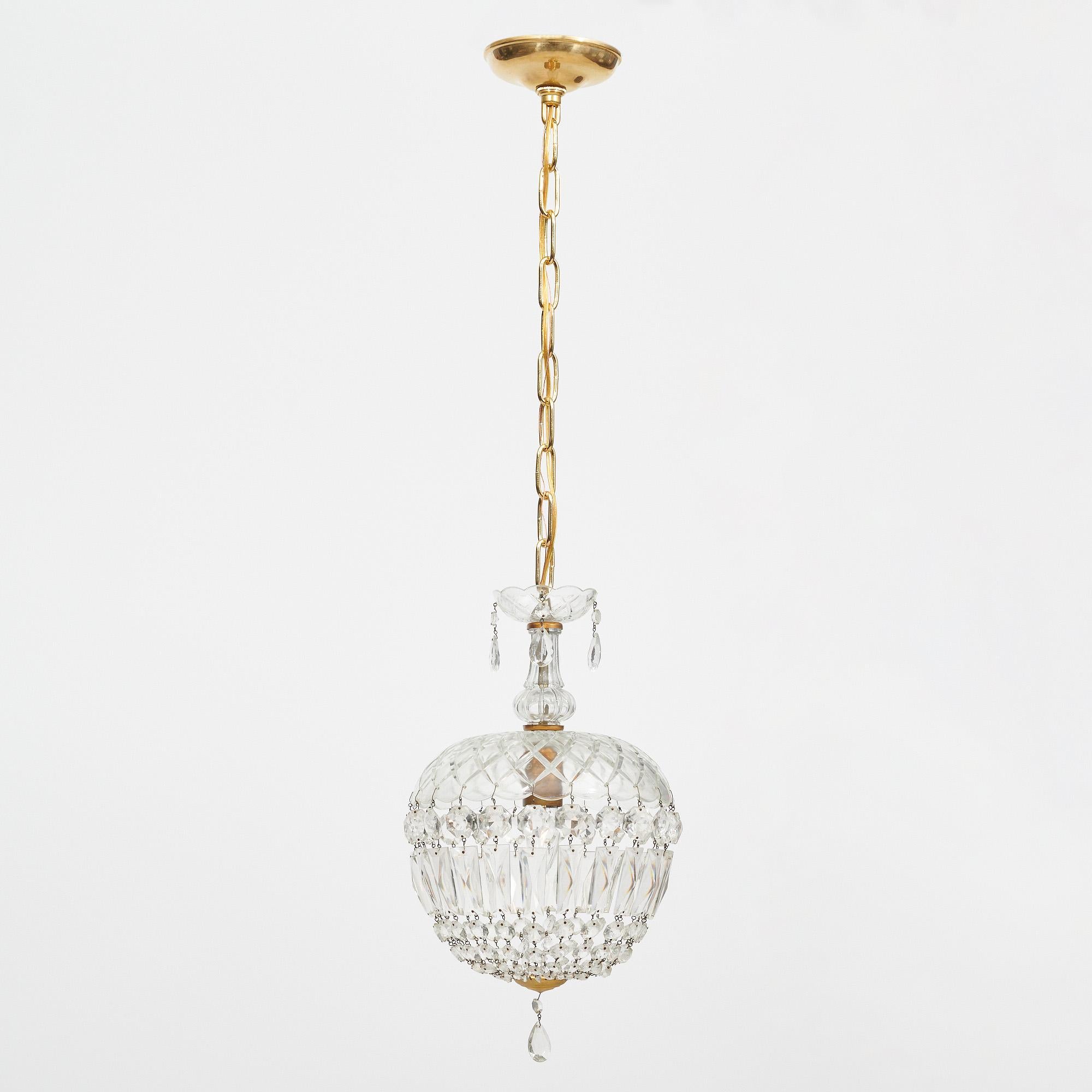 Chandelier/pendant from France in the iconic Baccarat bell shape. The crystal fixture top holds strands of cut crystal elements (cabochons) that come together with a delicate crystal finial. This piece has been newly wired to fit US standards. It is