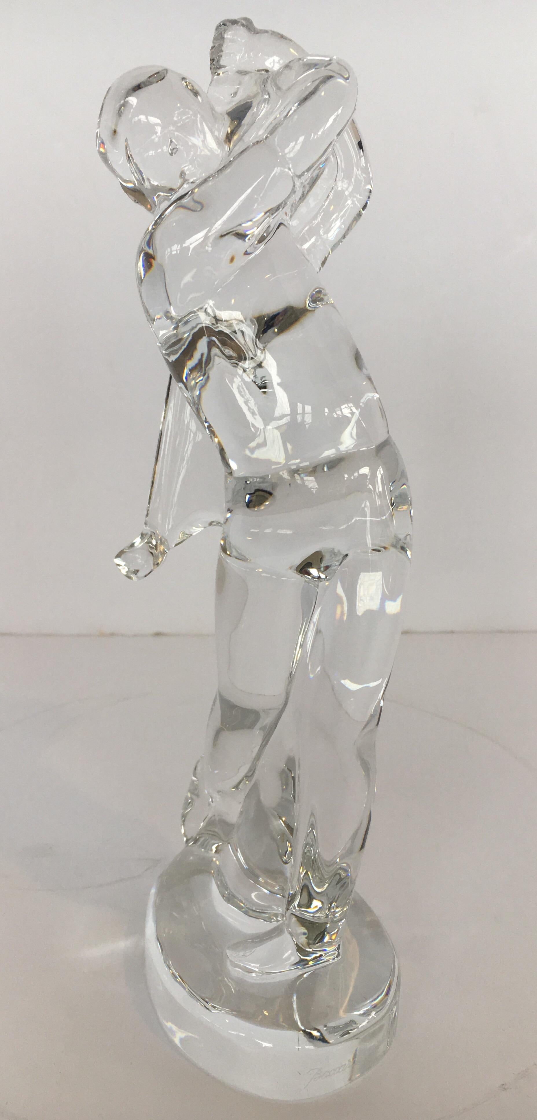 A Baccarat figurine depicting a male golfer swinging. This would be a perfect sculpture for any golf enthusiast, or for a sports lover looking for an elegant glass sculpture to adorn a cocktail table or office desk. Inscribed 