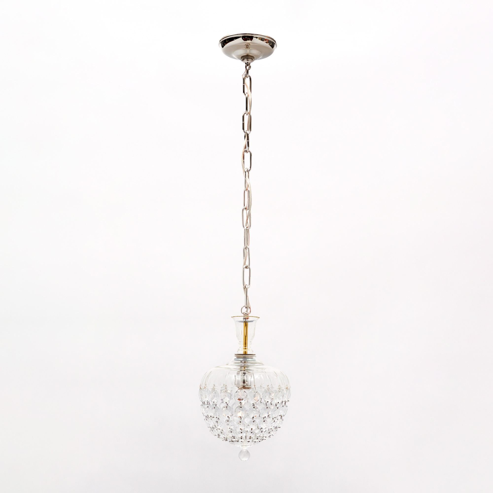 Lampadario/pendente proveniente dalla Francia con l'iconica forma a campana di Baccarat. La parte superiore dell'apparecchio in cristallo contiene fili di cabochon in cristallo tagliato che si uniscono a un delicato terminale in cristallo. Questo