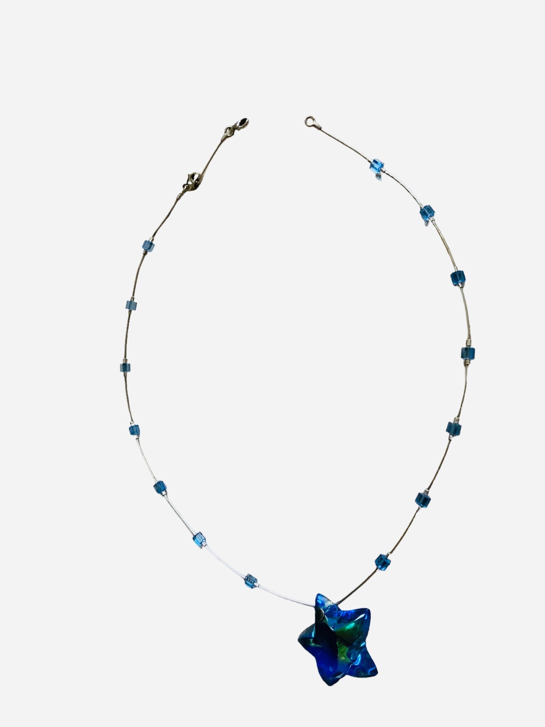 This is a Baccarat crystal blue sky  stars set of 925 silver necklace and a 750 gold pair of earrings. It depicts a silver thin rope shaped necklace enhance with small cylindrical blue sky crystal at each side and embellished with a blue sky star