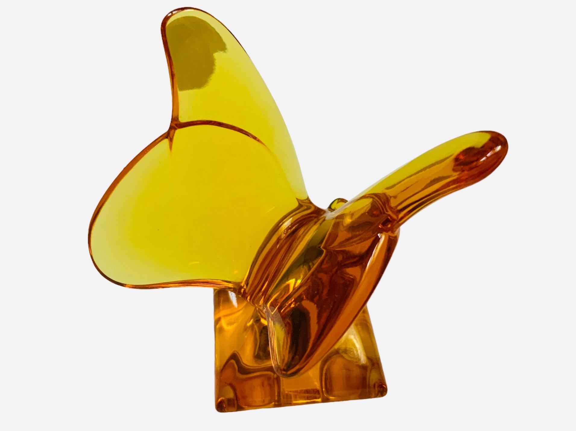 This is a Baccarat Crystal Butterfly sculpture/figurine . It depicts an amber color translucent crystal butterfly with its large wings open up supported also by a square crystal base. It has the acid etched hallmark of Baccarat  in one of the sides.