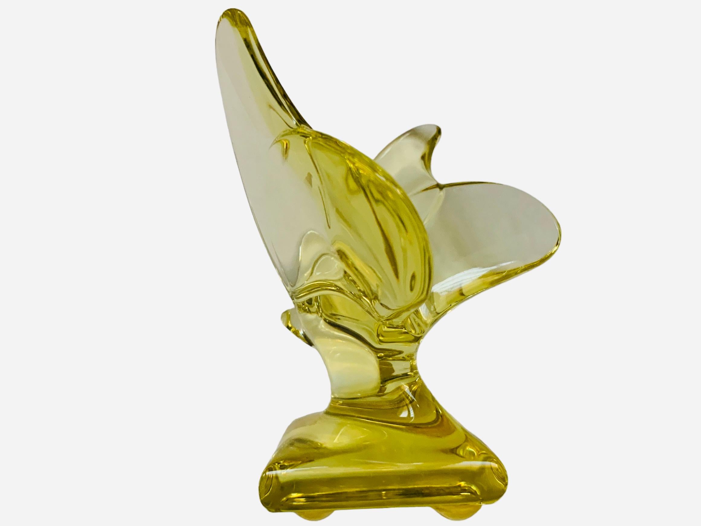 This is a Baccarat Crystal Butterfly sculpture/figurine . It depicts a light yellow color translucent crystal butterfly with its large wings open up supported also by a square crystal base. It has the acid etched hallmark of Baccarat  in one of the