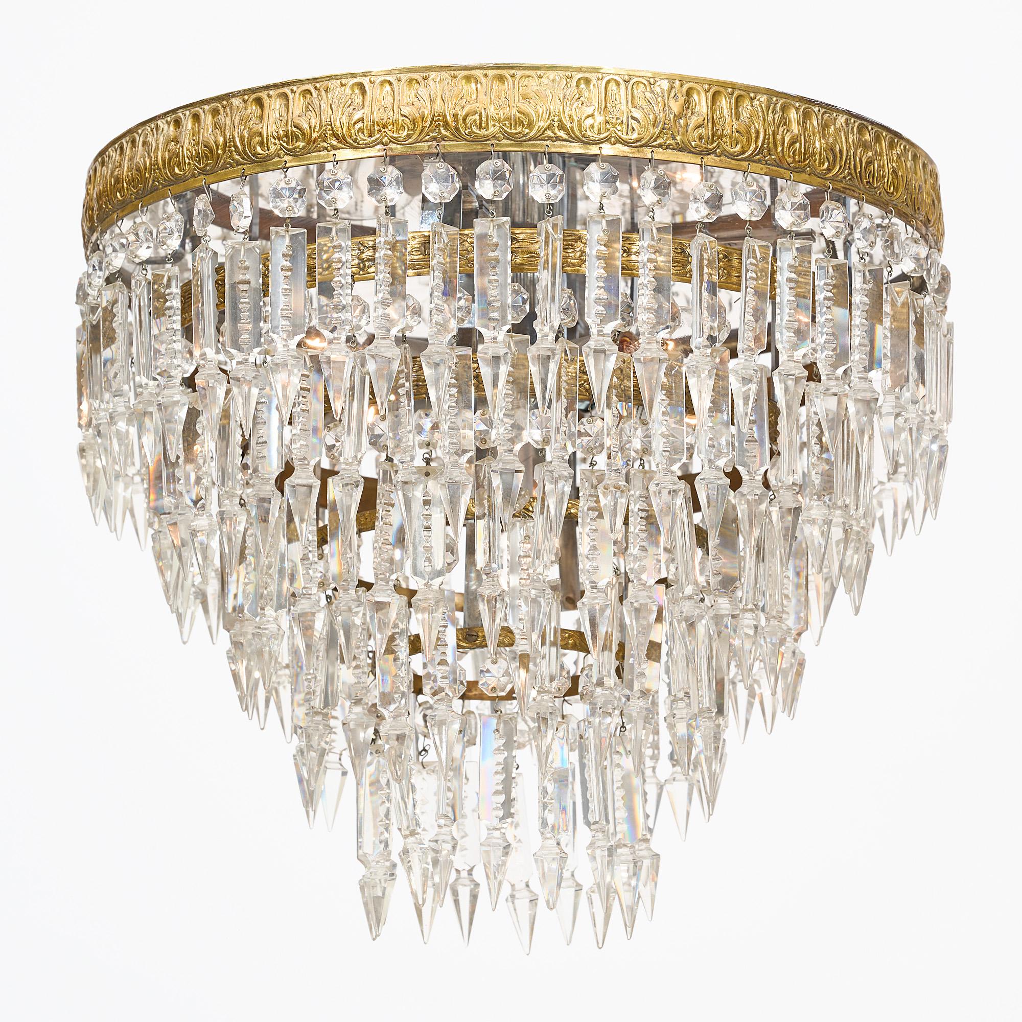 Exquisite pair of antique French Baccarat chandeliers from Paris. Adorned with meticulously cut crystal pendants, delicately suspended from embossed stacked crowns, these captivating fixtures exude timeless elegance. This pair features intricate