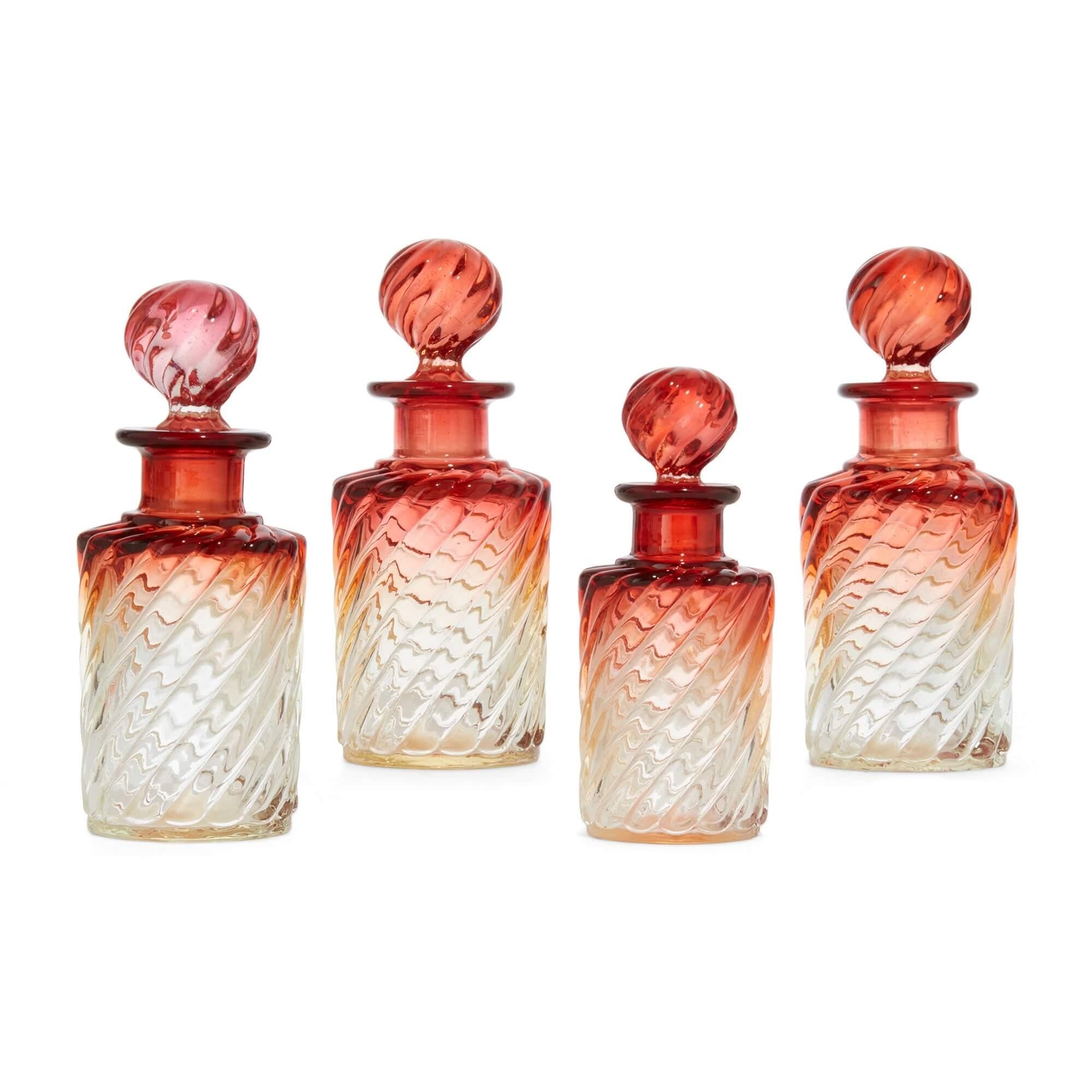 Baccarat crystal glass collection of bottles and trays 
French, 20th Century 
Largest: Height 4cm, width 24.5cm, depth 9cm 
Smallest: Height 12.5cm, width 4.5cm, depth 4.5cm

This elegant collection of amberina crystal glass bottles and trays was