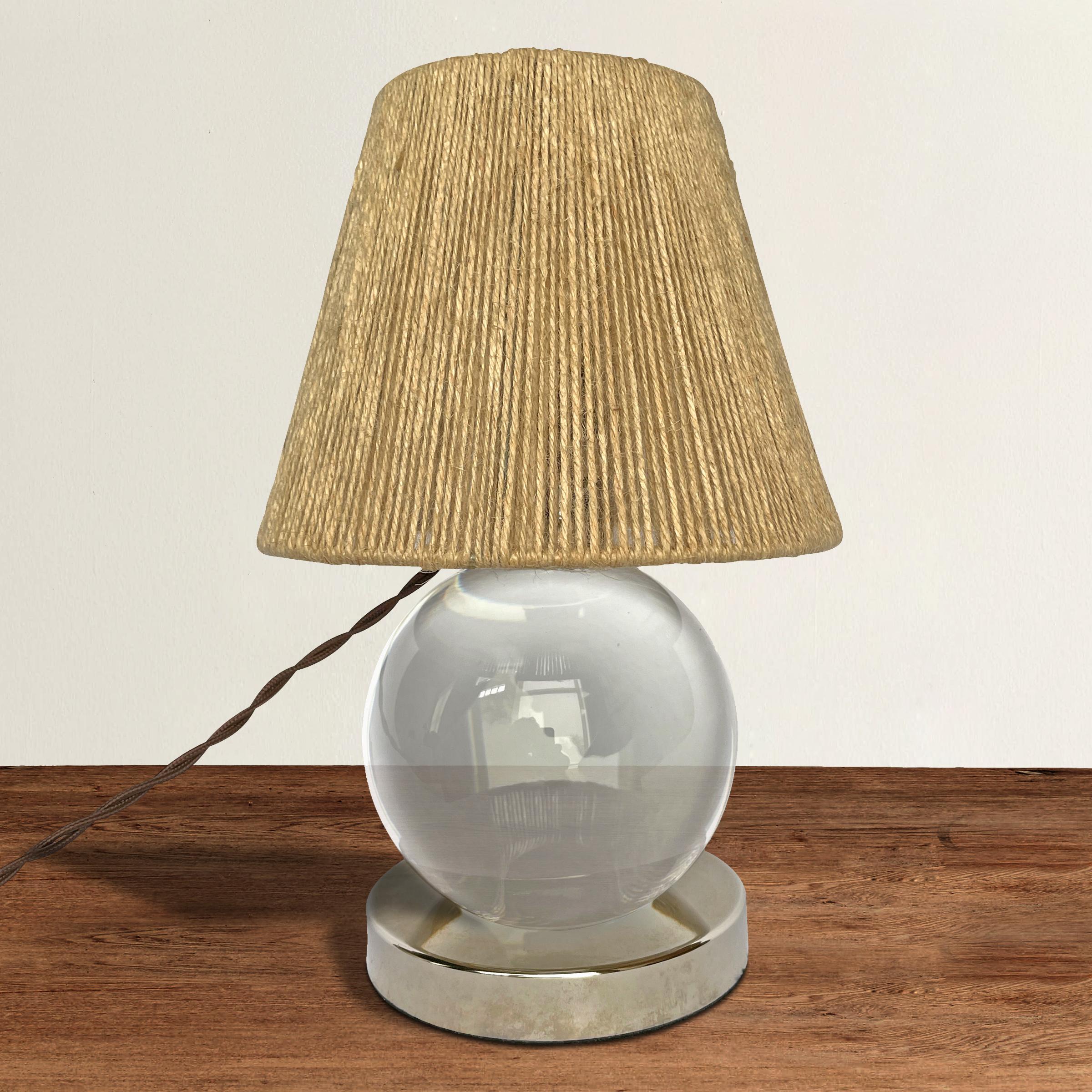 A chic French Baccarat table lamp, after Jacques Adnet, with a crystal sphere that rotates in a silver plate base, and with a newer string shade. Wired for US, and with a brown silk wrapped cord.