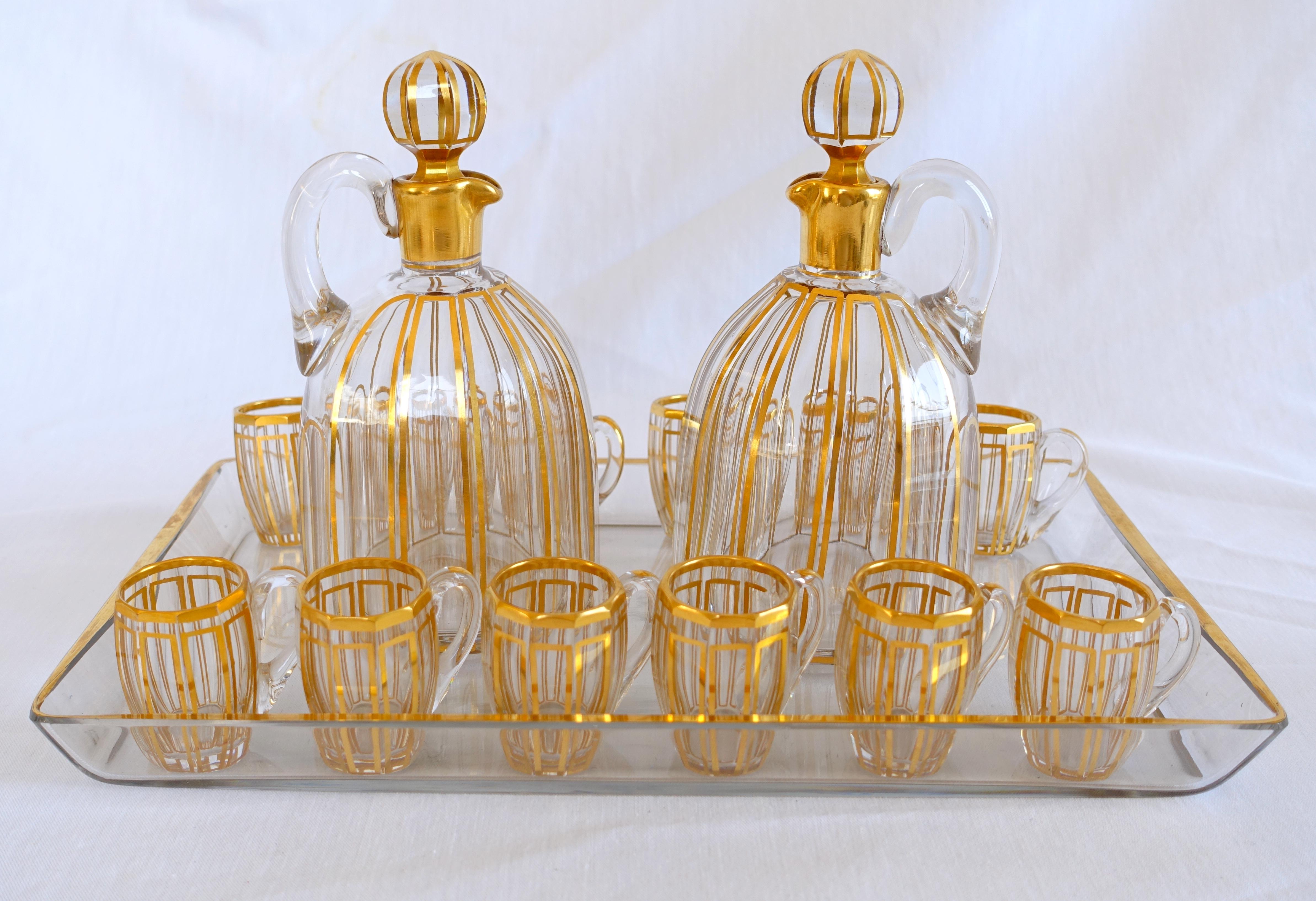 Stunning French antique Baccarat crystal liquor set for 12 guests composed of 2 bottles and 12 glasses (barrel-shaped cups with a handle).

Our set is an elegant, refined Louis XVI style model listed in early 20th century tableware catalogs (1907