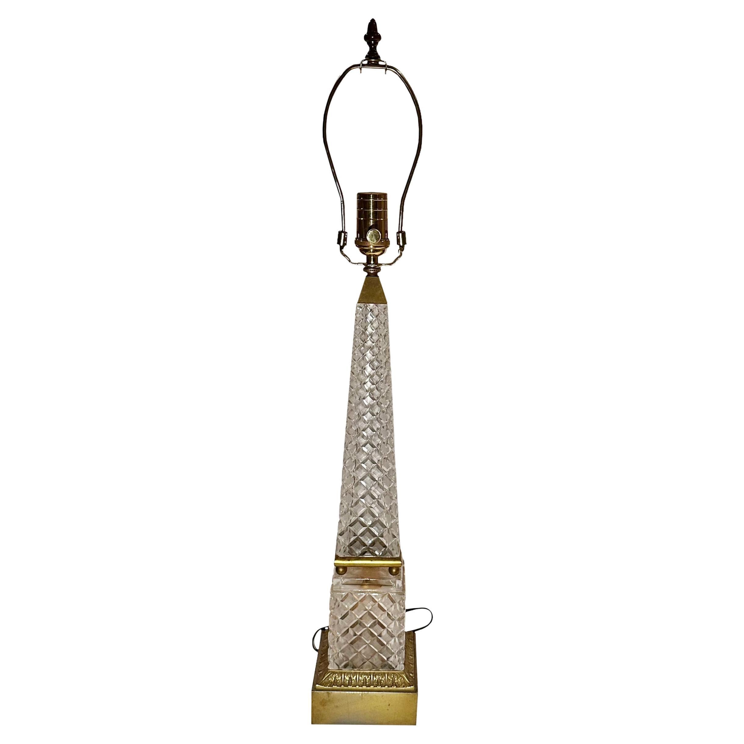 An exquisite obelisk crystal lamp by Baccarat. It is all crystal with a bronze dore cornucopia finial. Newly rewired and has a very high quality socket and silk cord.