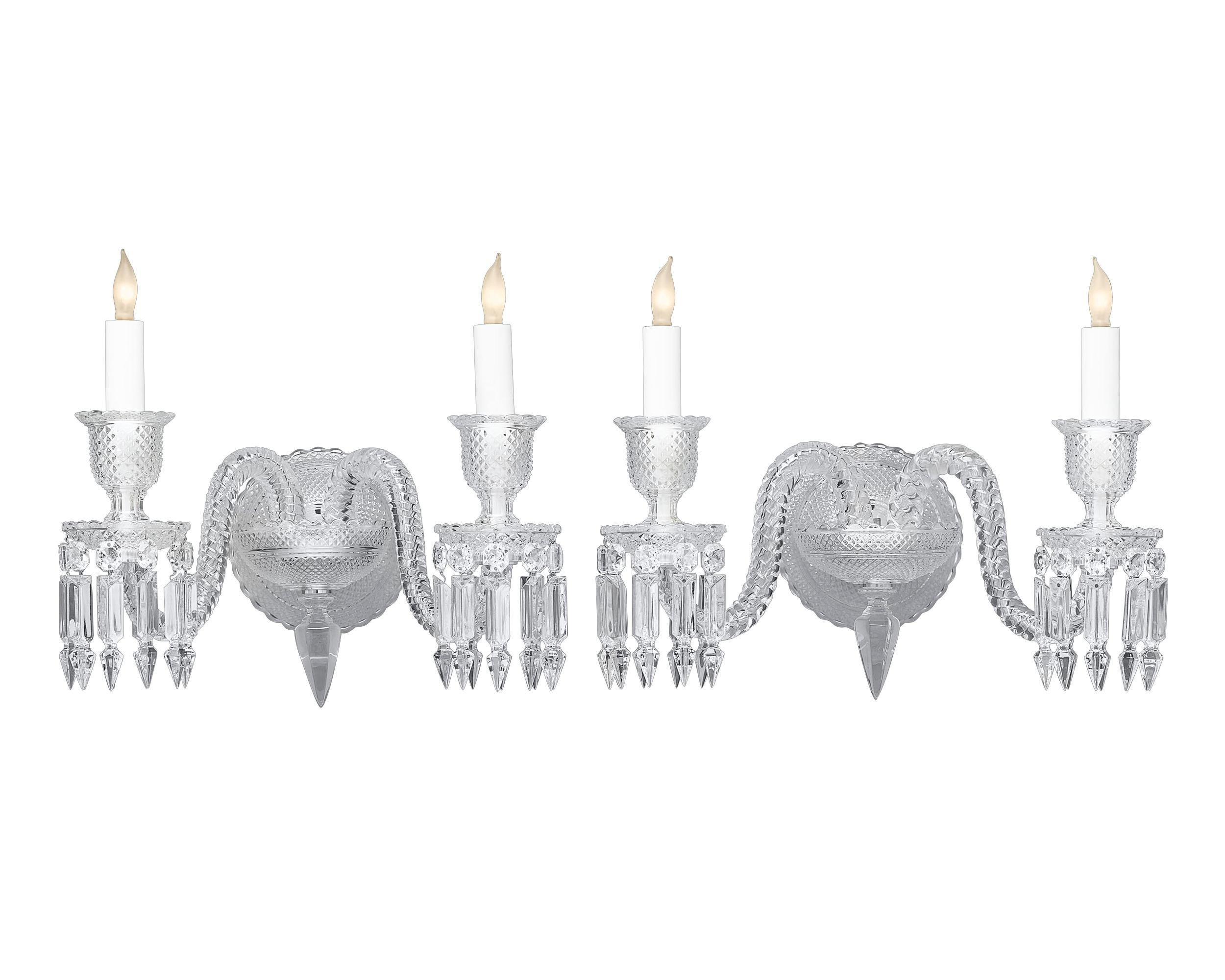 These exquisite crystal wall sconces by Baccarat beautifully illustrate that company’s genius for interior elegance. Adorned with a meticulous cross-hatched design, the sconces dance with light thanks to Baccarat’s iconic twist arms and fringes of