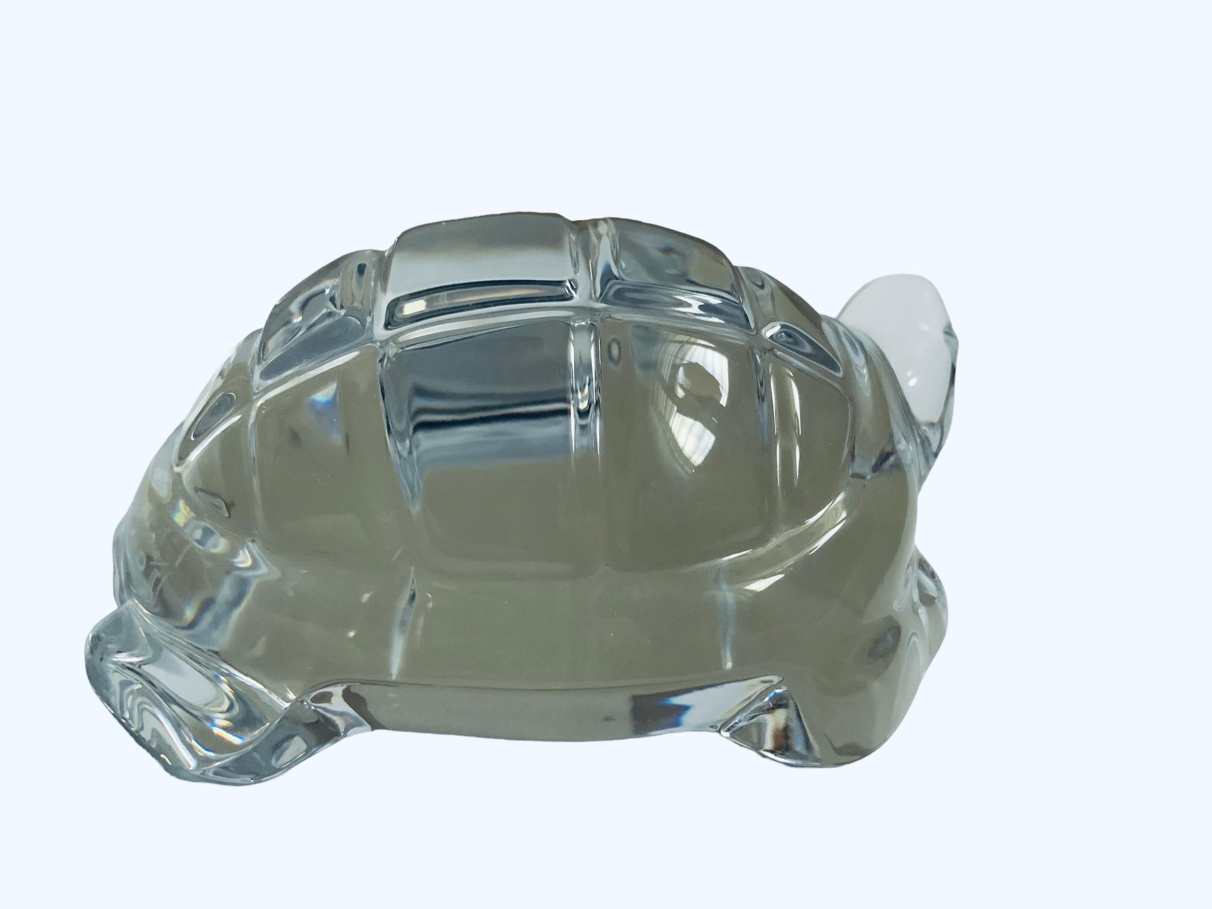 This is a Baccarat Crystal Turtle sculpture/paperweight. It depicts a turtle with an oval shaped clear crystal carapace, head, legs and neck. It has the acid etched hallmark of Baccarat, France below the base and also in one of the sides.