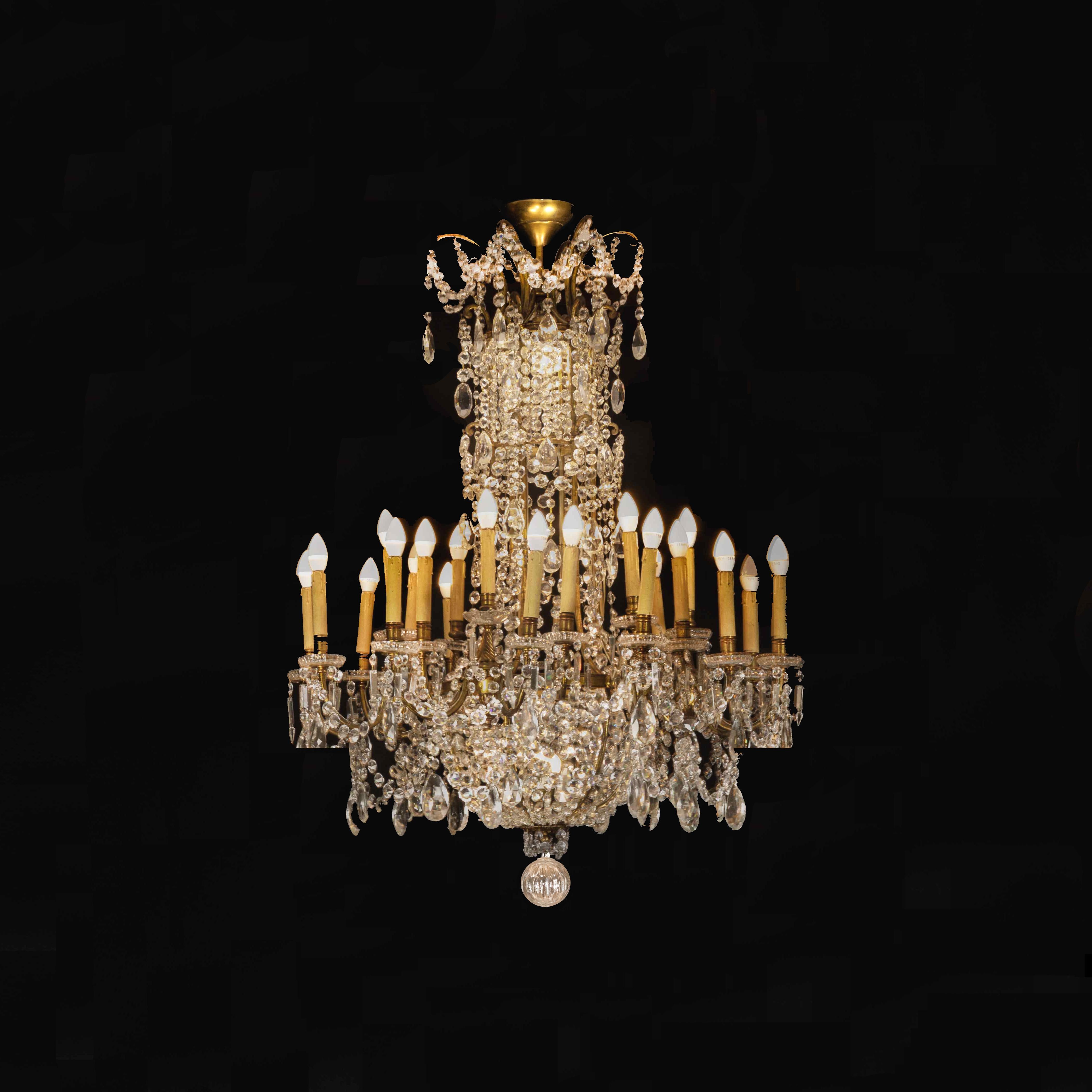 This Baccarat crystal and doré bronze chandelier of monumental size and opulent design is truly a splendid sight boasting 24 lights, distinguished by the oversized drops of crystals, which hang among garlands of luminous prisms from the doré bronze