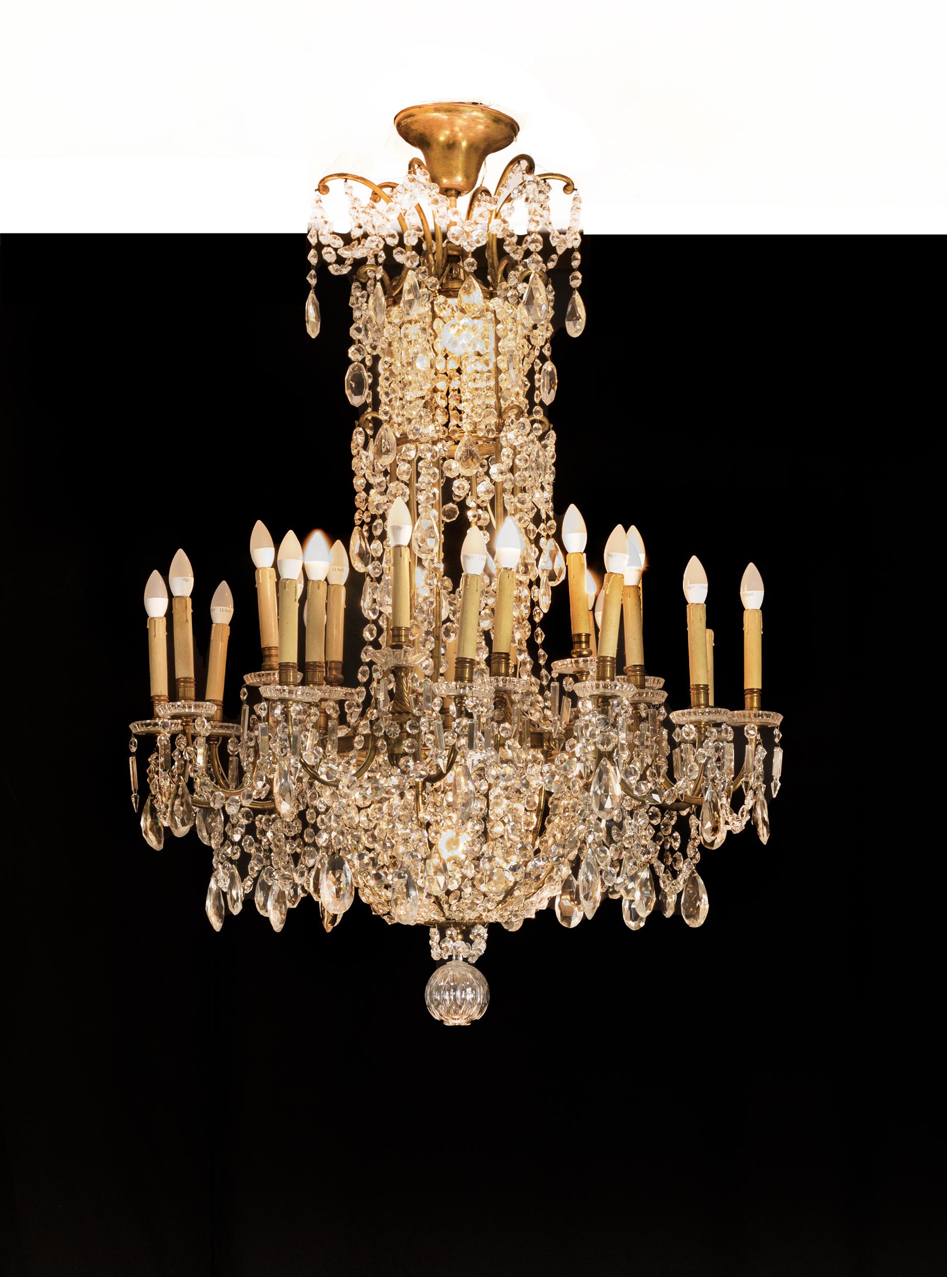 This Baccarat crystal and doré bronze chandelier of monumental size and opulent design is truly a splendid sight boasting 24 lights, distinguished by the oversized drops of crystals, which hang among garlands of luminous prisms from the doré bronze