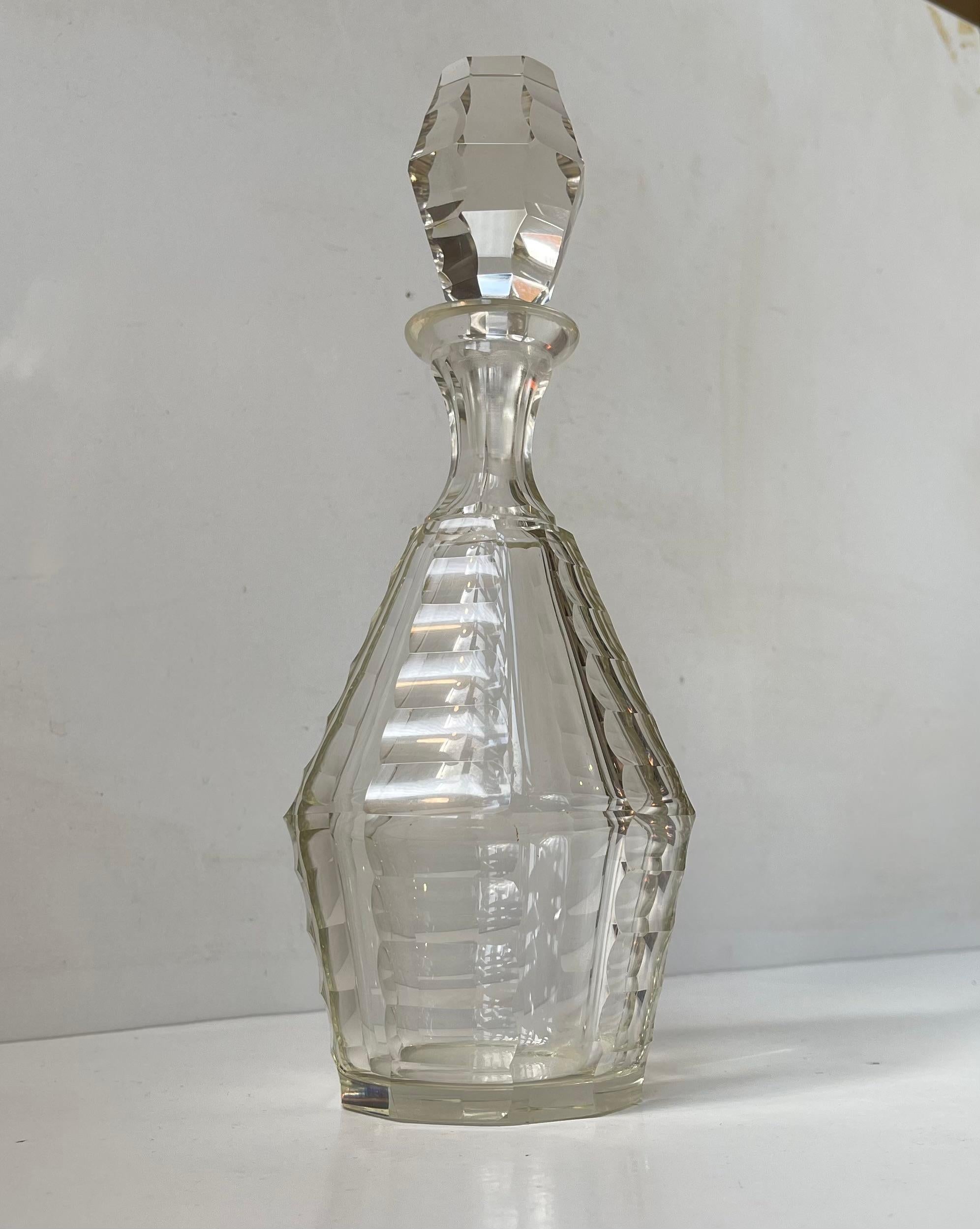 Exceptional 0,5 liter decanter in multi-faceted lead-crystal. Made in France during the 1920s or 30s by Baccarat. All the faceted edges are beveled and smooth. Distinct architectural Art Deco styling throughout the piece. Measurements: H: 26 cm