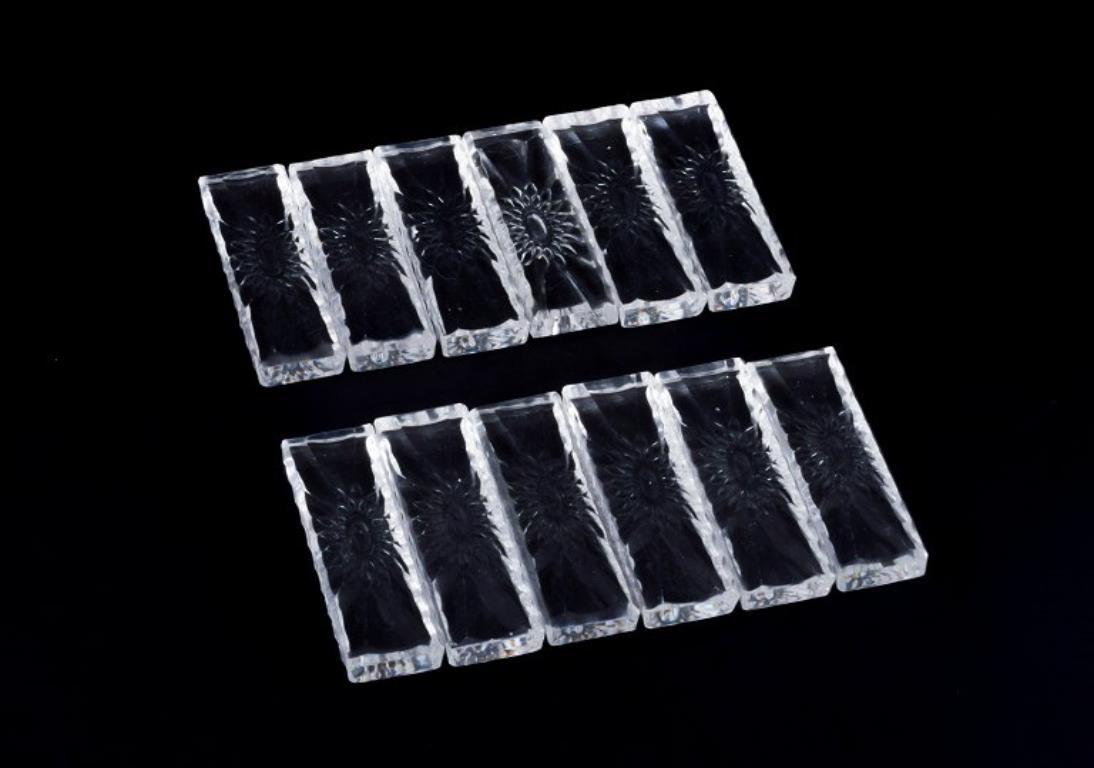 Baccarat, Francia. Un juego de doce reposacuchillos en vidrio artístico transparente. Motivo floral. Facetado. Hecho a mano.
1930s.
Perfecto estado.
Dimensiones: L 8,3 cm x An 2,6 cm x Al 1,2 cm.