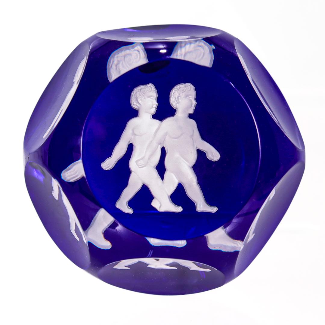 A fine, faceted French art glass paperweight.

From the Zodiac series. 

By Baccarat.

With a white sulphide depicting the Gemini twins Castor & Pollux on a blue ground. 

Marked with an acid-etched Baccarat factory mark to the base.

Simply a