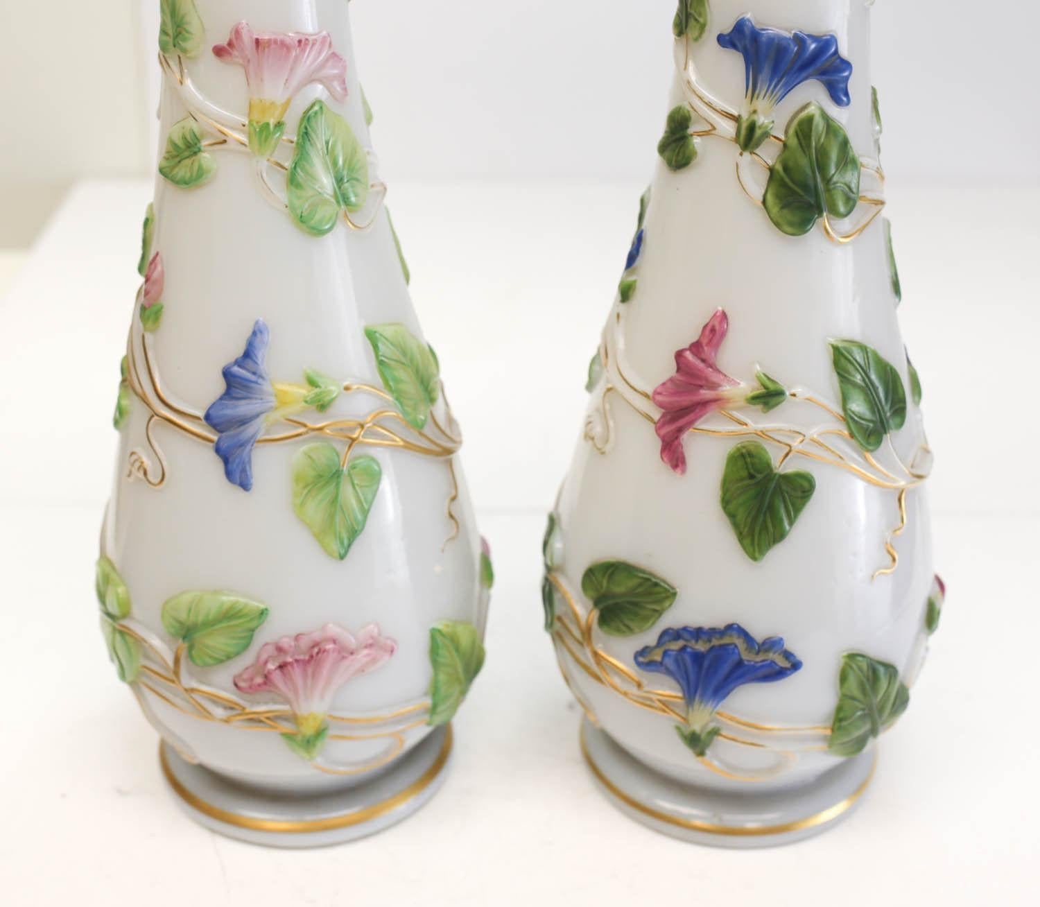 A pair of charming Baccarat French Opaline enamel hand painted glass vases, circa 1900. Beautiful blue and pink hand painted enamel florals to the white Opaline glass vases. Unmarked, but determined to be Baccarat. Weight approx., 20
