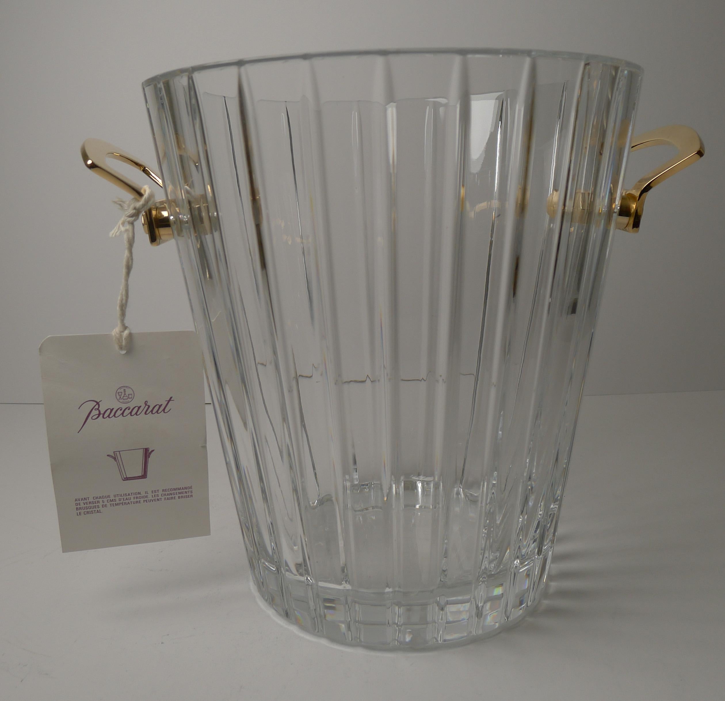 A fabulous top-notch champagne bucket or wine cooler by Baccarat, beautiful thick heavy crystal with a simple linear cut decoration.

Each of the handles is made from gilded bronze and stamped with the Baccarat mark; the underside of the crystal