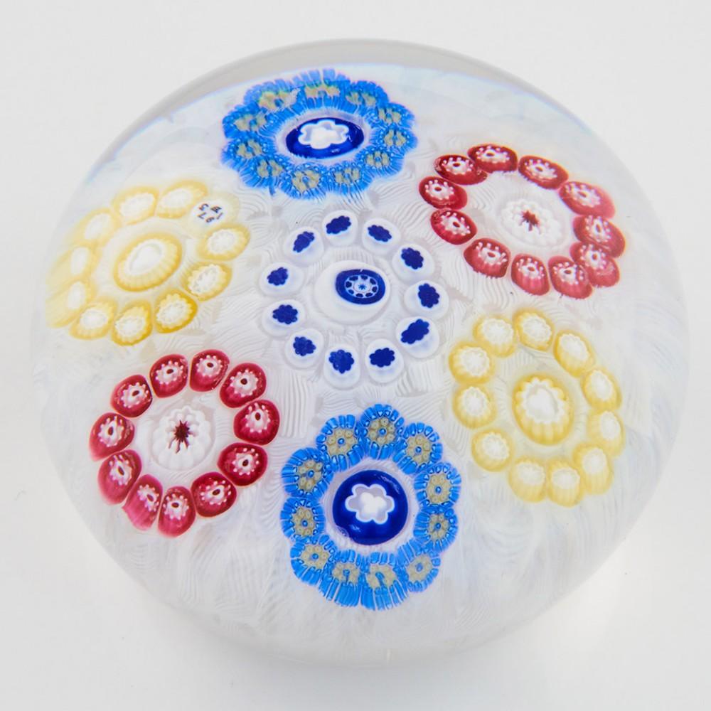 Titolo : Un fermacarte Baccarat Millefiori su fondo di mussola 1973
Data: 1973
Origine: Francia
Caratteristiche : Sei rondelle millefiori (un anello concentrico) intorno alla rondella centrale su un fondo di mussola
Marchi : Canna firmata B1973 in