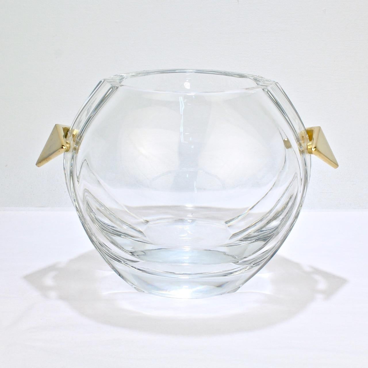 A fantastic midcentury Baccarat glass ice bucket.

With chevron shaped gilt bronze handles, a spherical body, and shaped sides.

Simply top quality design in very rare form from one of the world's leading glass houses!

The base bears an