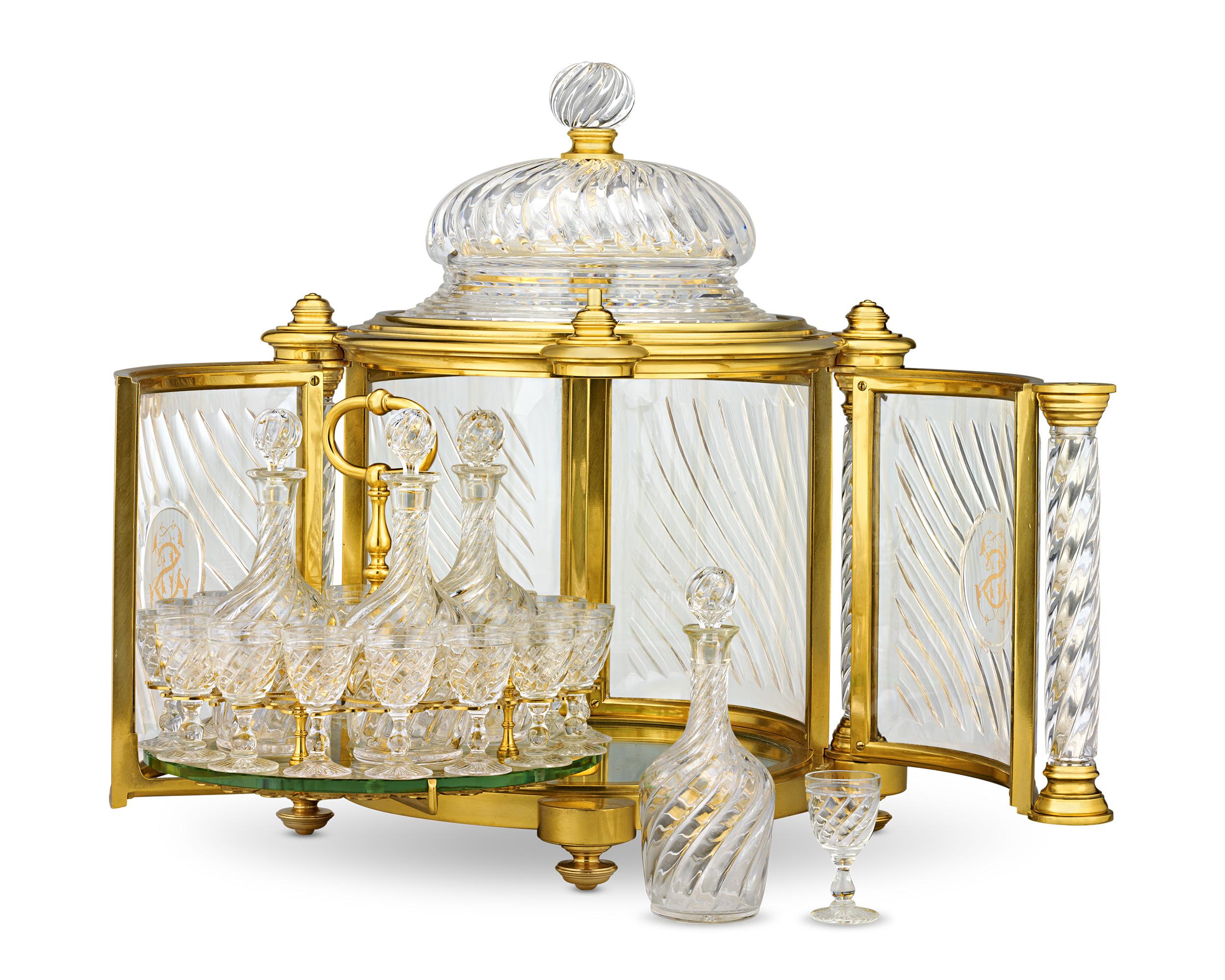 This monumental 19th-century ormolu liqueur casket is exemplary of the masterful craftsmanship of the famed luxury firm Baccarat. The doors open to reveal a mirrored base and a glass rack that cradles four exquisite bottles with stoppers and sixteen