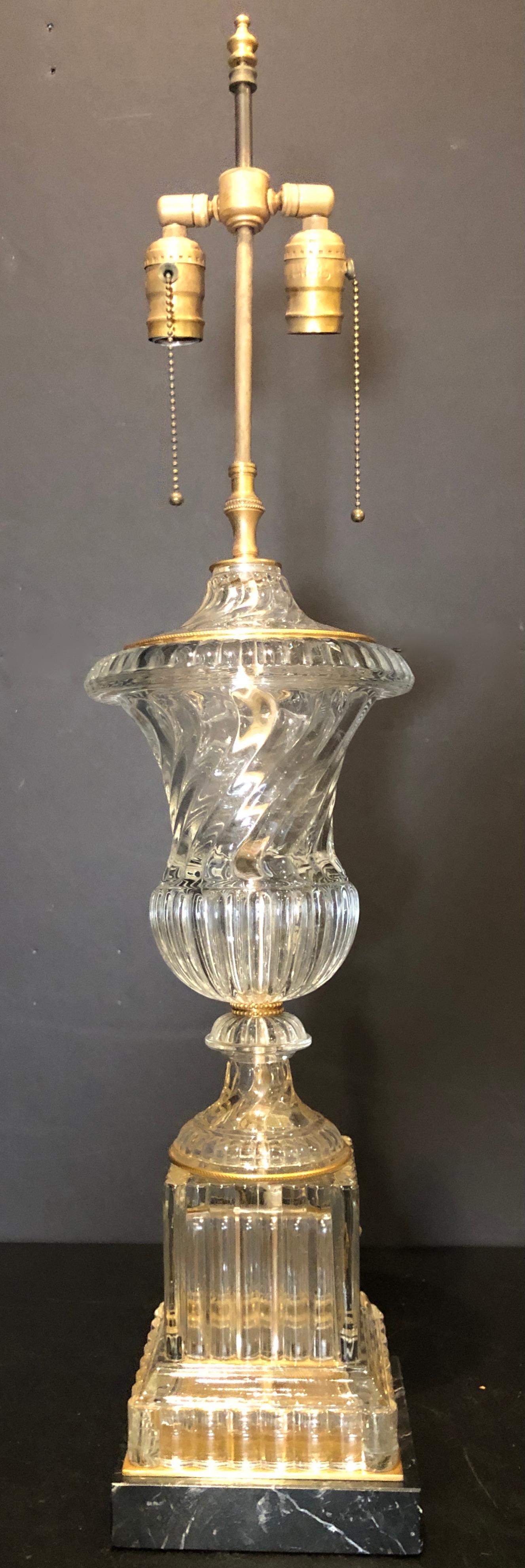 Baccarat spiral urn form table lamp. Baccarat style urn or vase form lamp on square black veined marble base with subtle gilt bronze embellishments, by Paul Hanson Lighting Co. 
Base is 6