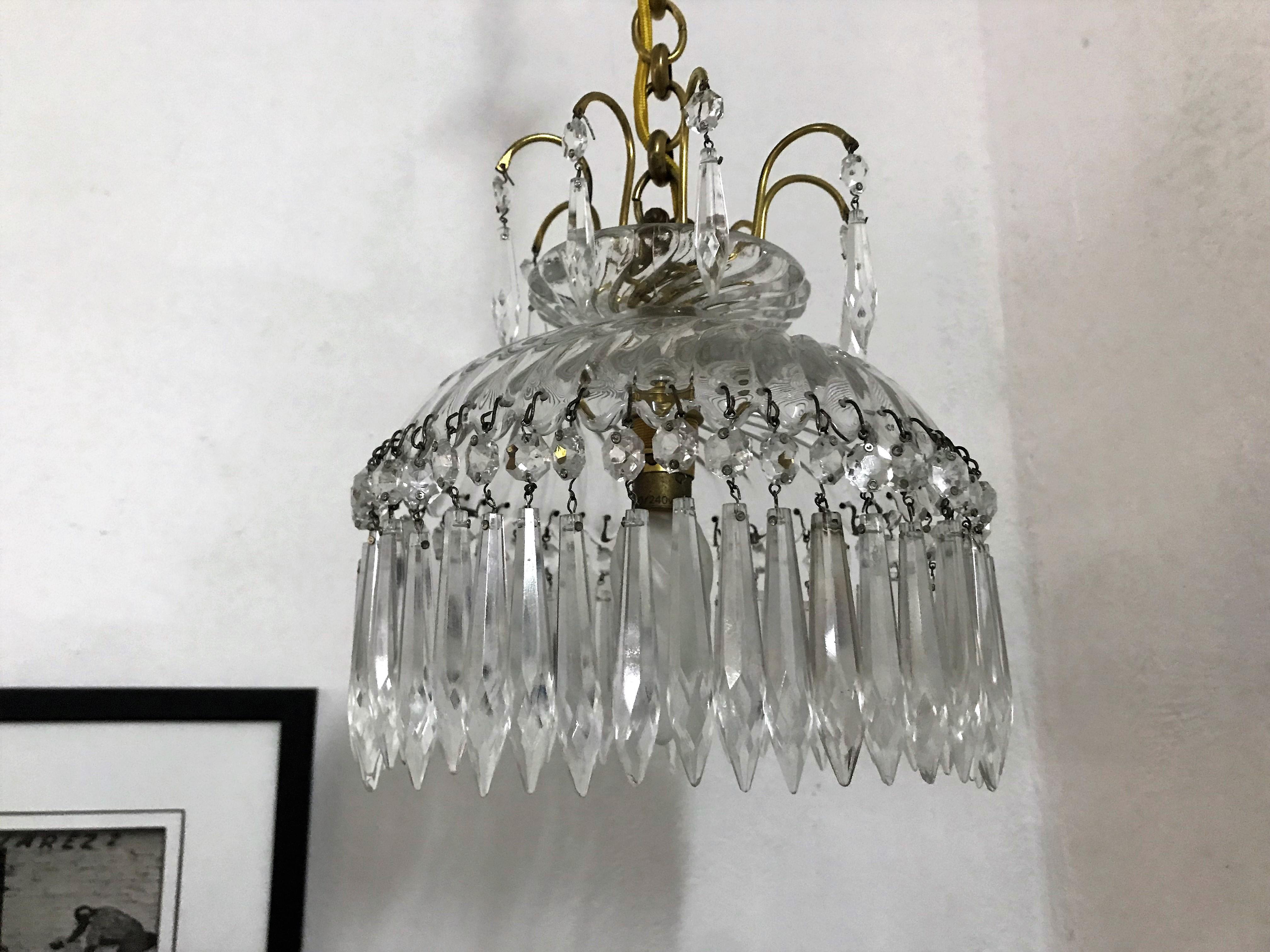 Charming chandelier with handcut prisms made by Baccarat in France, circa 1950, in bronze and lead crystal.
It bears the acid etched Baccarat mark but it proved difficult to photograph, it is circled in red in the last photograph.