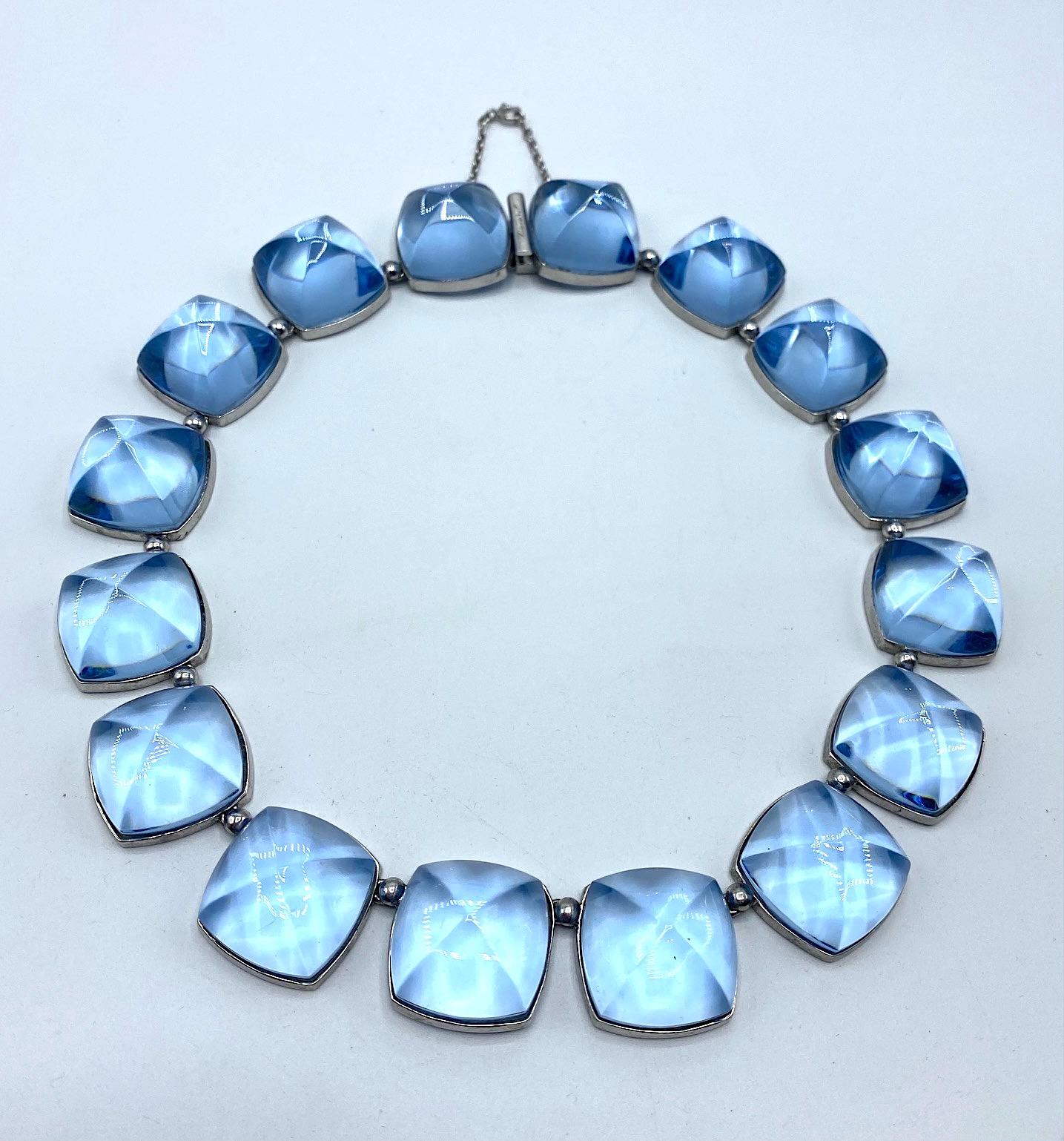 Presented is a stunning light sky blue crystal and sterling silver necklace by French glass house Baccarat. The necklace is comprised of 15 links of measuring 1 inch square separated by a small bead link. Each glass link is has a large .94 of an