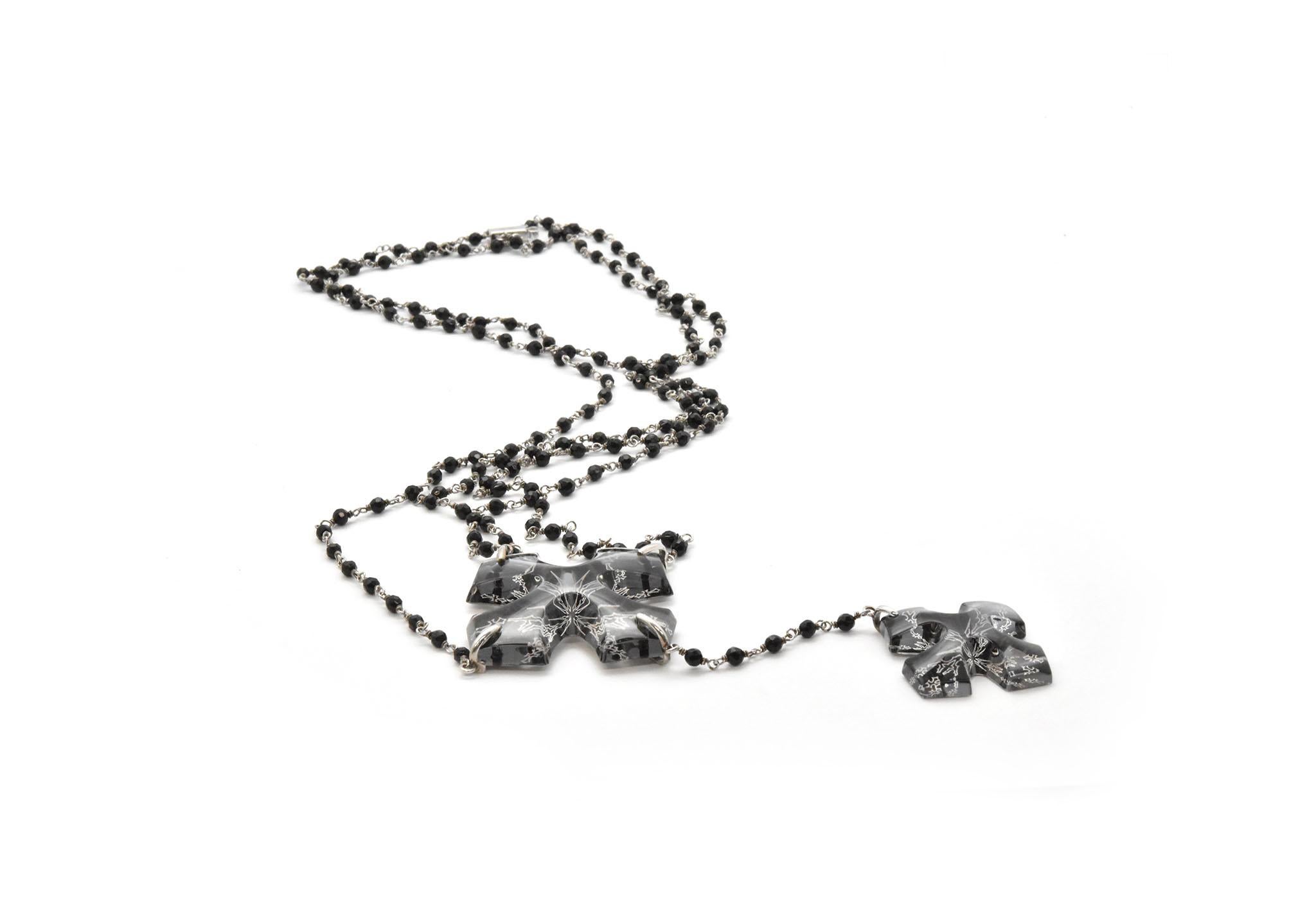 This necklace is designed by Baccarat in sterling silver and full lead crystal. A double cross pendant is the focal point of the necklace with a unique black bead and sterling chain series. The pendant section measures 5.5” long, and the largest