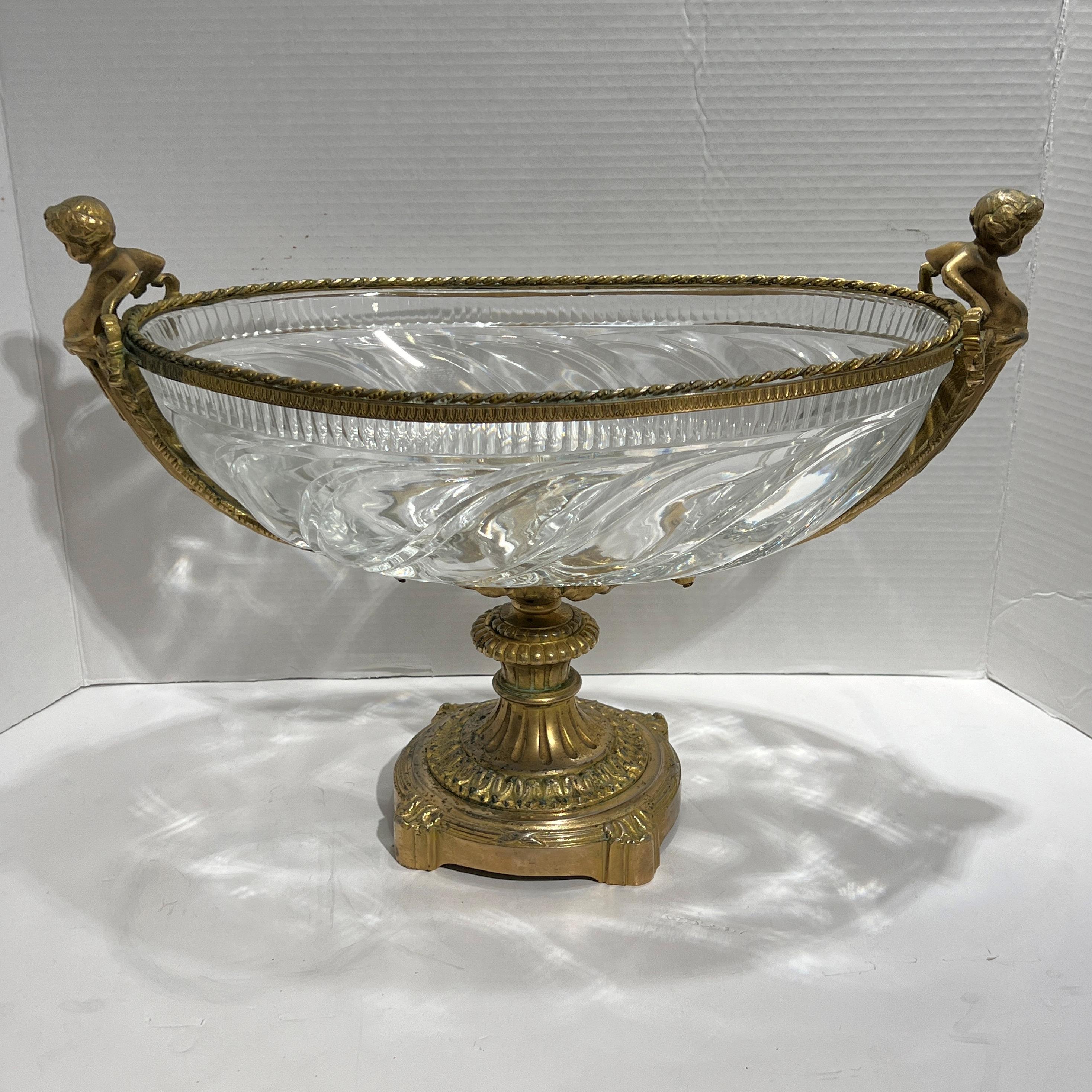 Antique (19th century) French centerpiece bowl in the Louis XVI neoclassical style with an exceptional molded crystal bowl with elegant gadrooned designs, with gilt bronze frame including cherub handles and single footed base.  Apparently unsigned. 