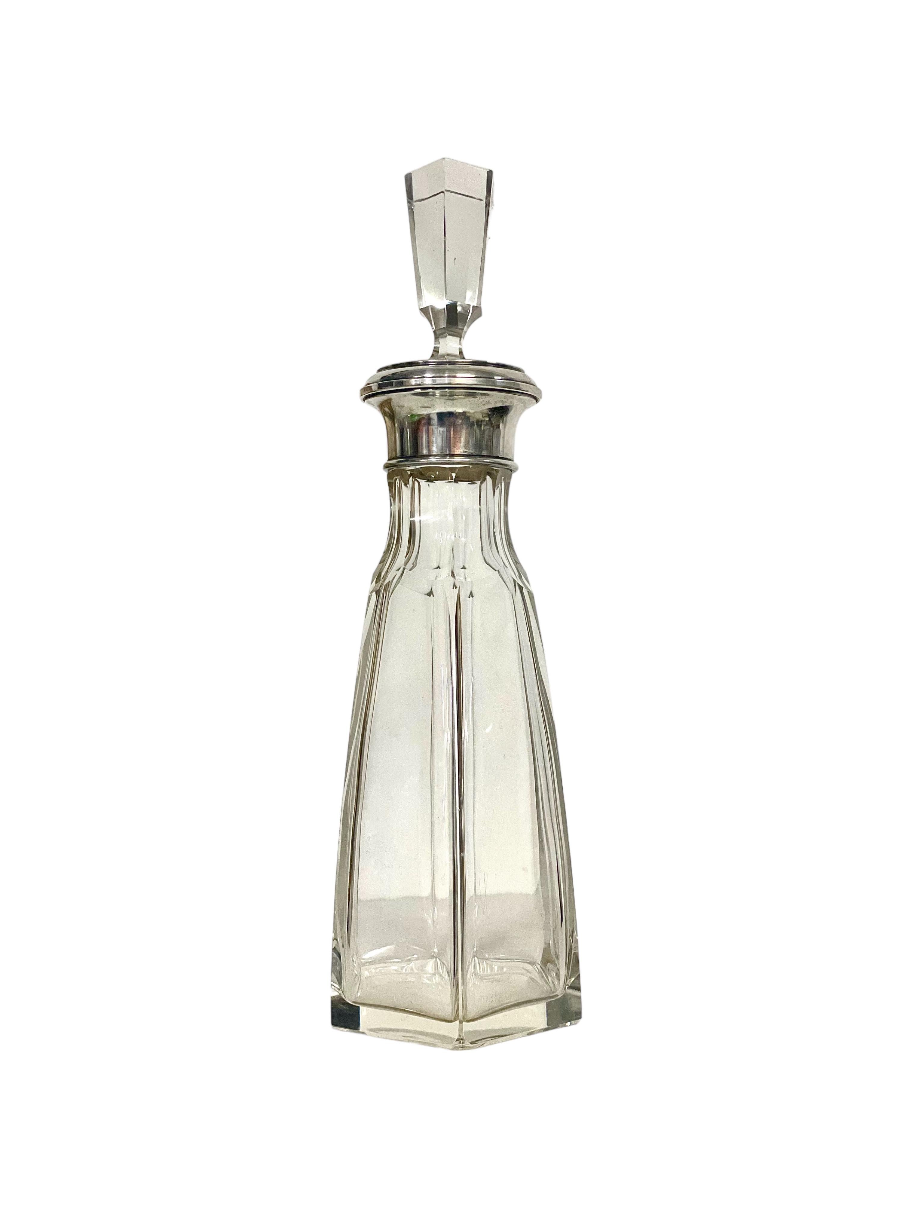 A very stylish cut crystal lidded decanter made by renowned crystal manufacturer Baccarat. This vintage piece of classic barware features a silver-plated collar and oversized stopper, its faceted sides cut to echo those of the decanter. Taking the