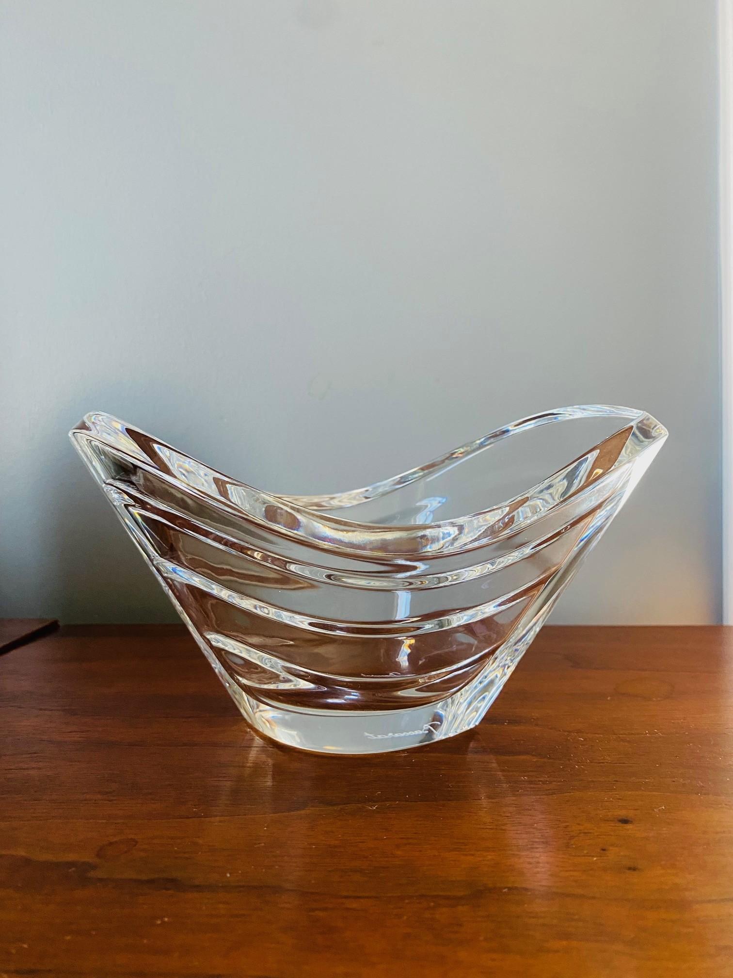 Luxurious bowl from crystal-sculpting experts Baccarat.  With its legacy in crystal, Baccarat displays craftmanship and beauty in its unique pieces.
The edge of the vase undulates throughout clear crystal with waves traveling down the side in five