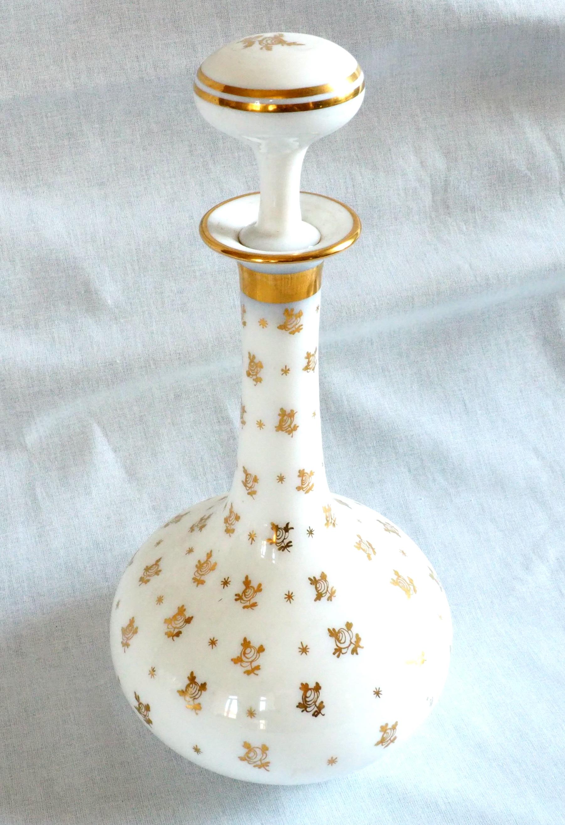 Un raffinato set da acqua bianco opalino di Baccarat: una bottiglia d'acqua, una bottiglia di melissa o liquore, una zuccheriera, due bicchieri e il vassoio.
Ogni pezzo ha una decorazione dorata dipinta a mano con motivi di rose.
Il set è completo