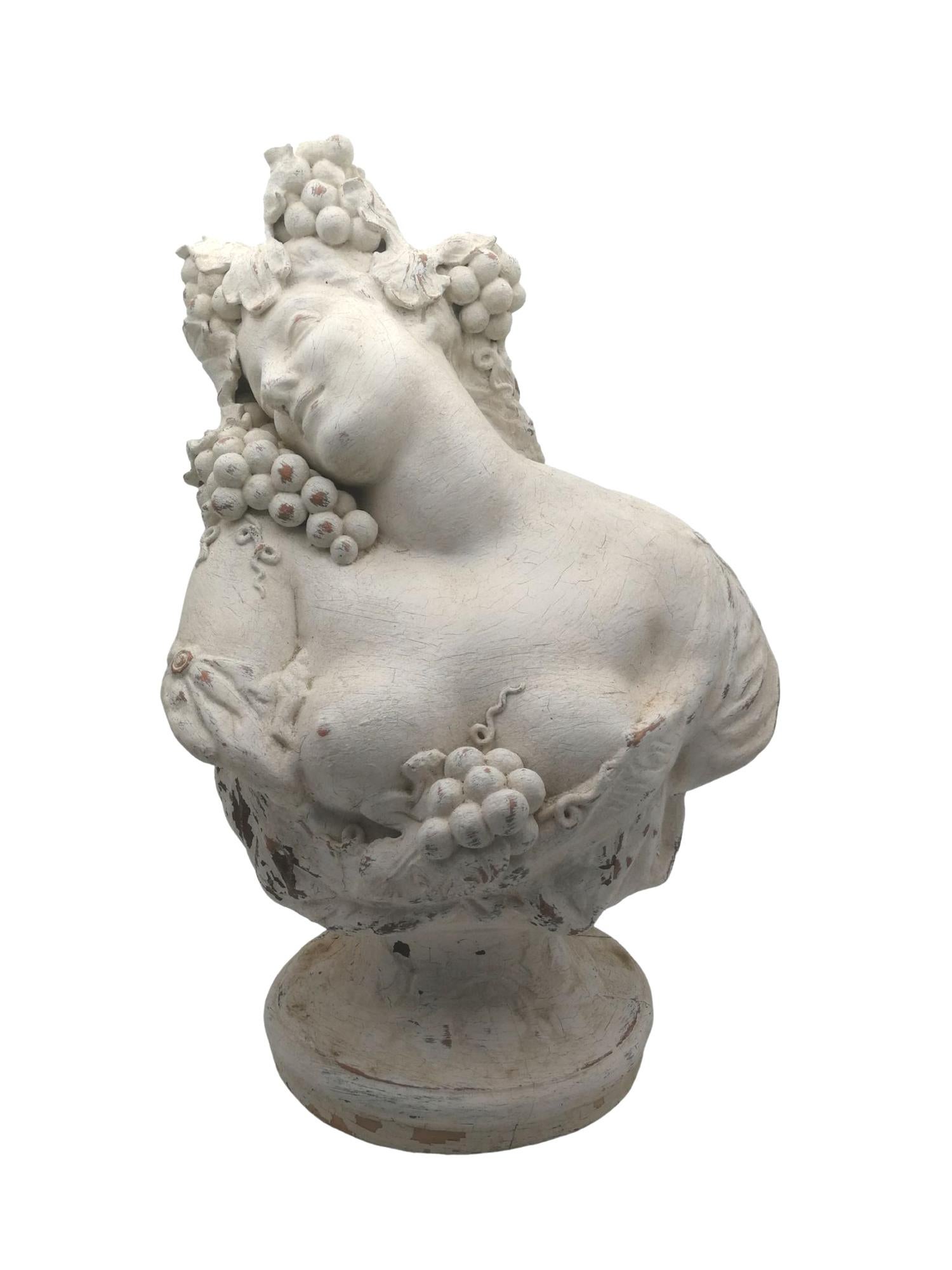 Beautiful Art Nouveau bacchant in plastered terracotta; her mane with bunches of grapes, leaves and vine tendrils, the inclination of her head with her sensual expression of satisfaction and her smile together with her generous breasts make this