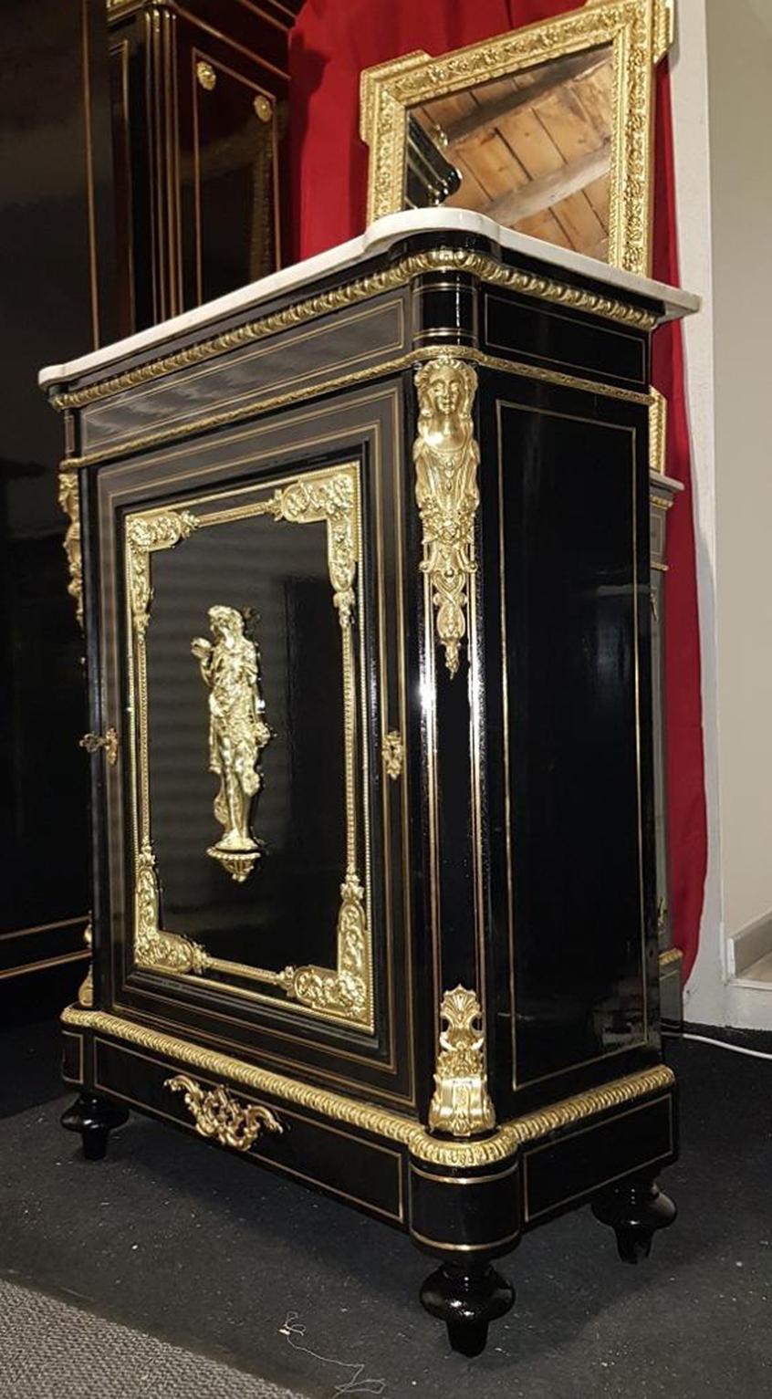 Marquetry Boulle cabinet with brass filets and an important ornamentation of gilt bronze. On the doors you will find a beautiful bronze representing Bacchus the God of the Fertility and Wine.
White Carrara marble top and the inside part is in