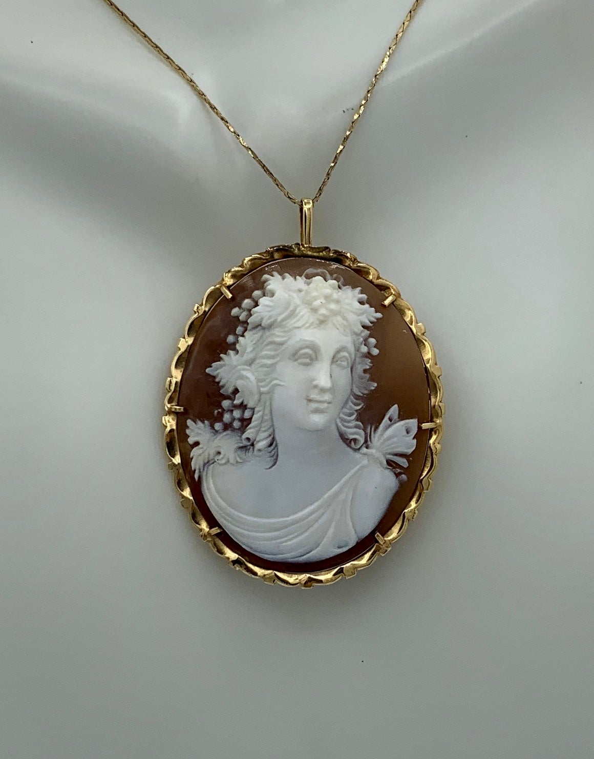 This is a stunning and very rare antique Art Deco - Victorian - Belle Epoque Cameo Pendant or Brooch of a magnificent hand carved face of Bacchus, also known as Dionysus, with a Butterfly on the shoulder and set in 14 Karat Gold.  The face of