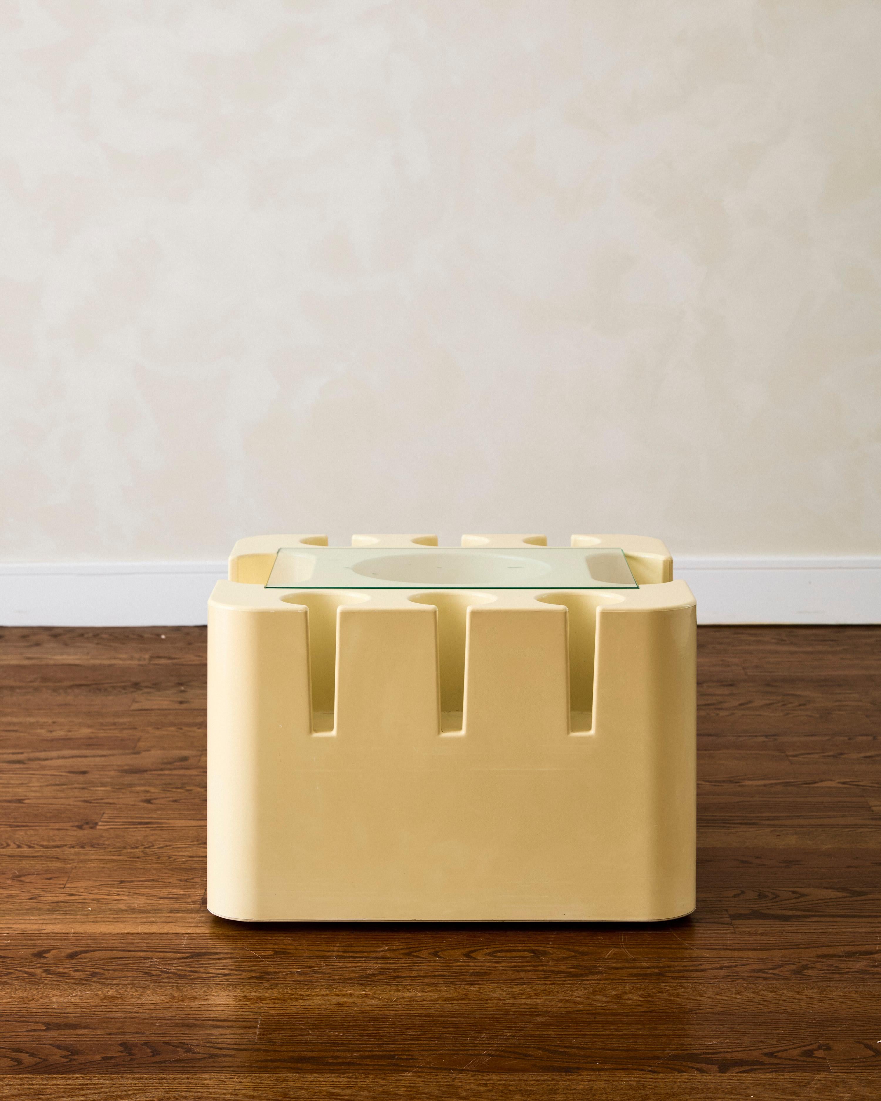 Table d'appoint Bacco de Sergio Mazza pour Artemide, fabriquée en plastique jaune, dotée de porte-bouteilles de vin et de liqueur, et surmontée d'une surface en verre.