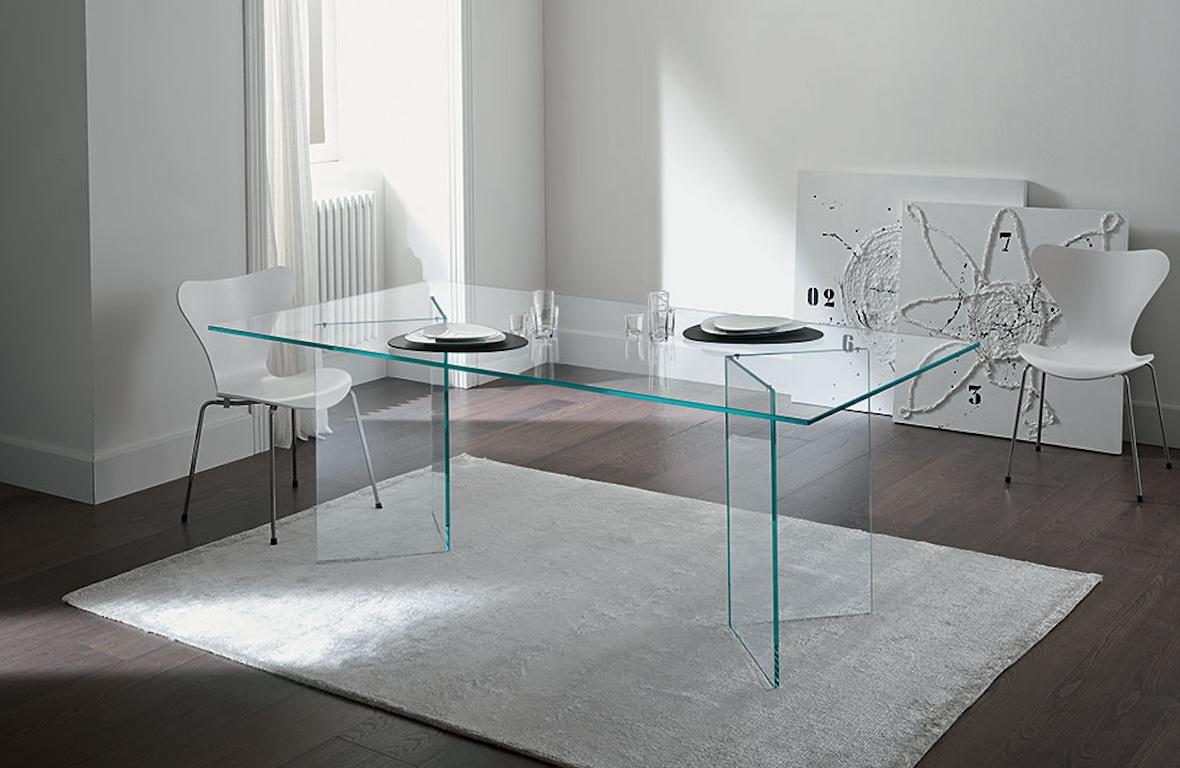 The glass table Bacco is composed of a top available in transparent, extra clear or smoked glass and of a base made of two mirroring glass supports that rest on the floor. Its clean lines are particularly suited for minimalistic decors because they