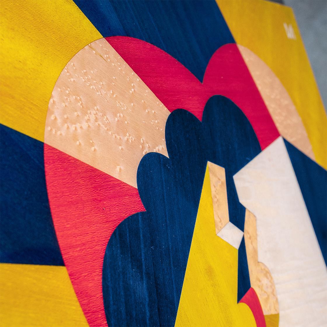 Bacio (Kuss) ist die erste Tafel einer fesselnden Reise durch das Leben zweier Menschen, die erst ein Paar und dann Eltern werden, und zeigt eine wunderschön gearbeitete geometrische Holzintarsie mit leuchtenden Blau-, Gelb-, Fuchsia- und Weißtönen.