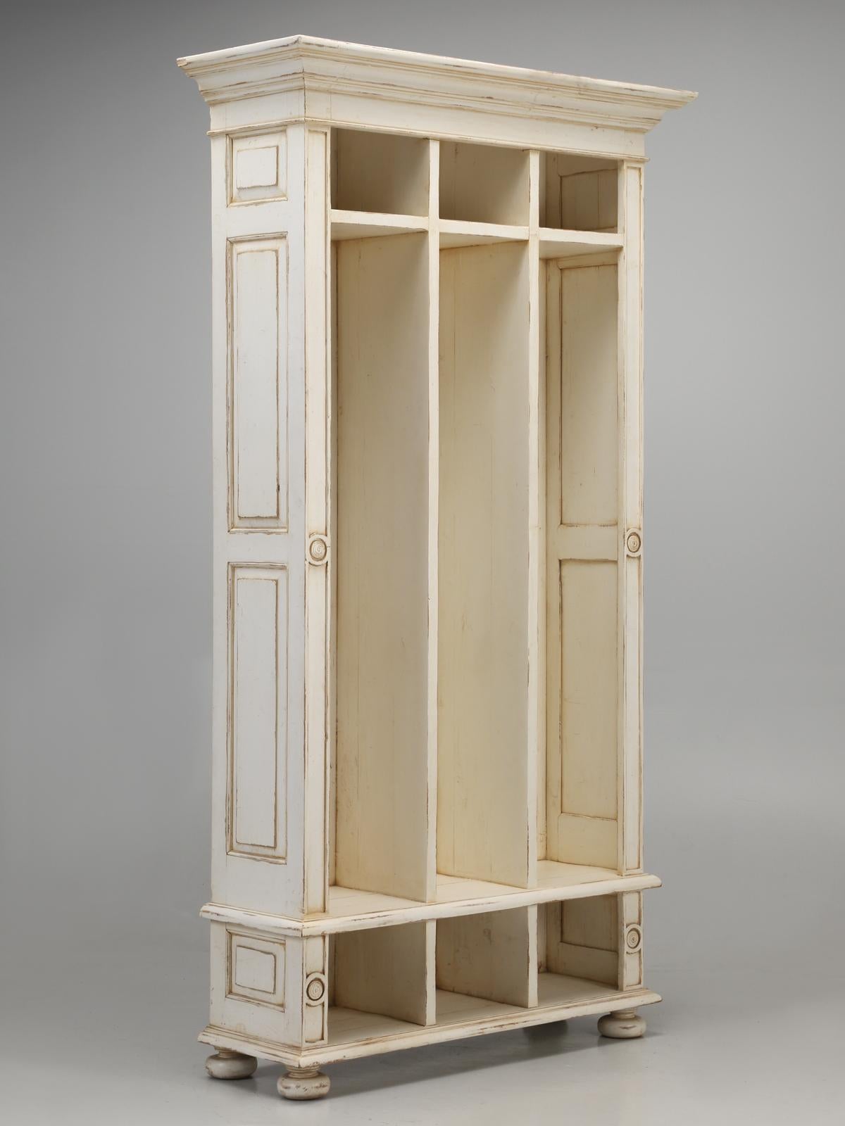 Back hall coat, hat and shoe cabinet. The ideal back hall cubby-hole cabinet, for the family’s coats, hats and shoes. This is an older reproduction, made by an off-shore company, with a nice distressed cream-colored paint.
